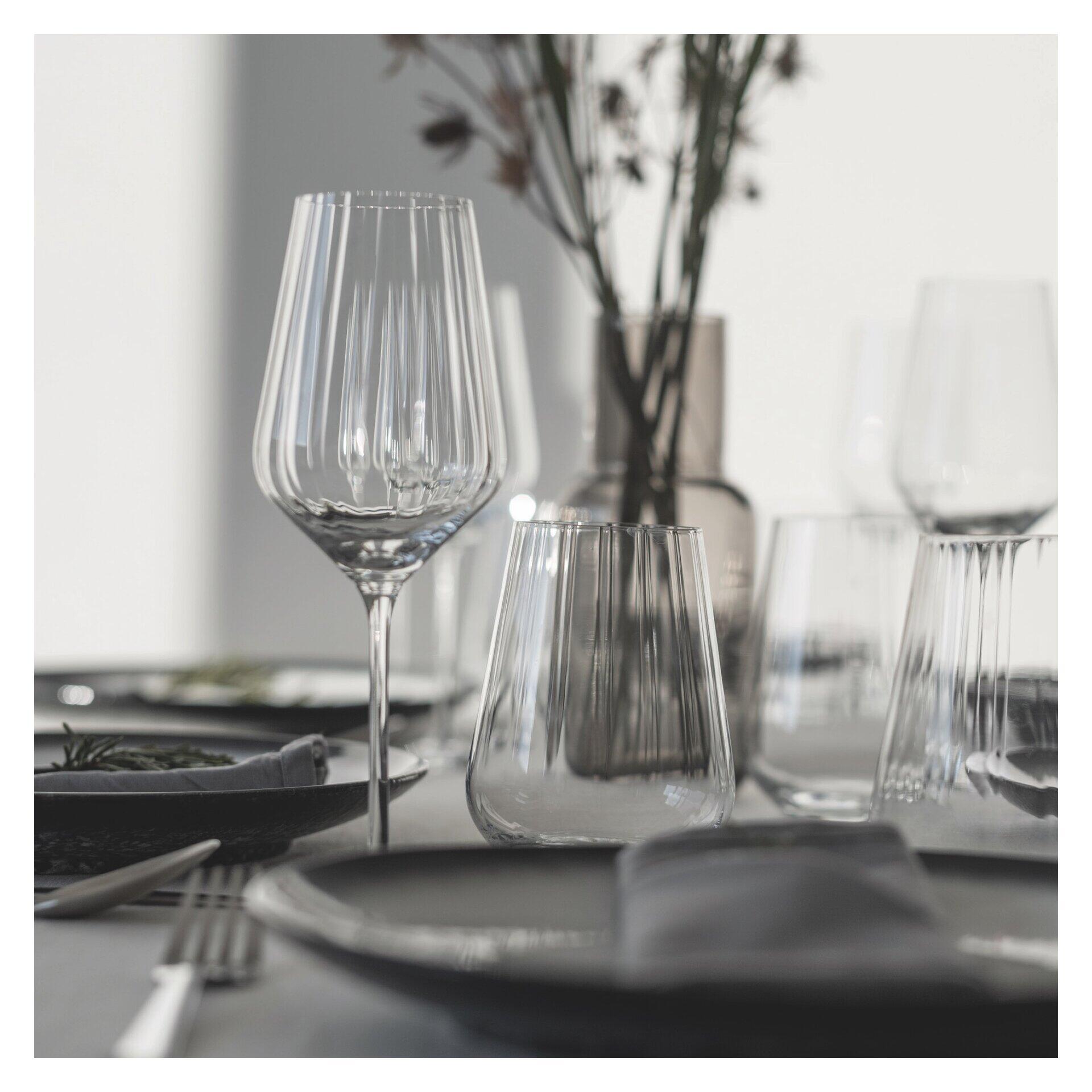 Reliefstrukturiertes Rotwein- und Wasserglas-Set in einer stilvollen Tischdekoration mit vertikalen Linienstrukturen und einer erhöhten Perspektive.