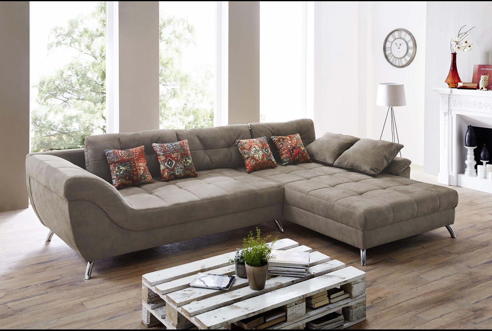 Wohnlandschaft San Jose in L-Form mit chromfarbenen Füßen, tiefen Sitzflächen und zwei roten, gemusterten Kissen, aus einer erhöhten Perspektive fotografiert, die den gesamten Umfang und das moderne Design zeigt.