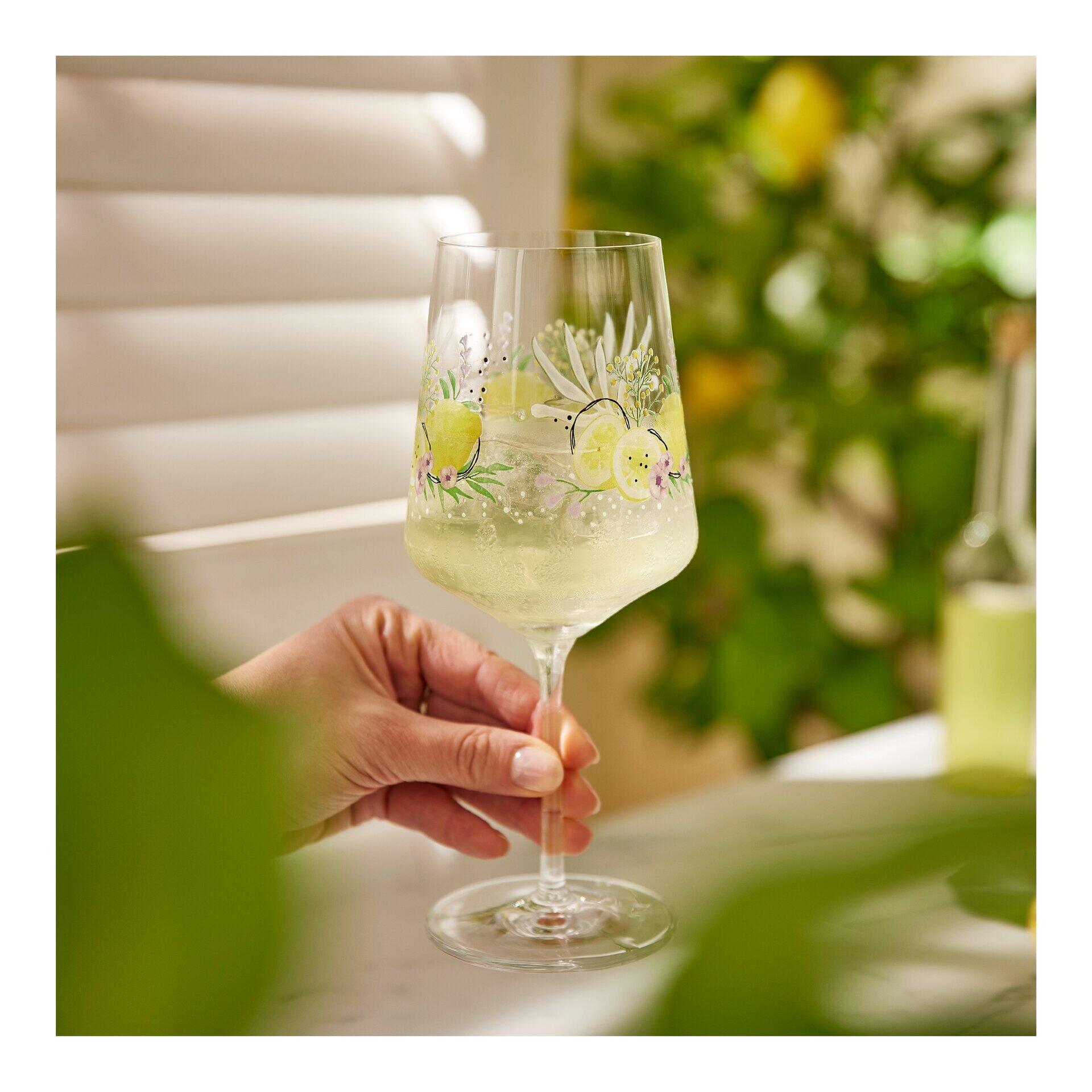 Aperitifglas-Set mit elegantem, schlankem Design und zartem Blumenmuster, gezeigt aus einer leicht unteren Perspektive in der Hand.