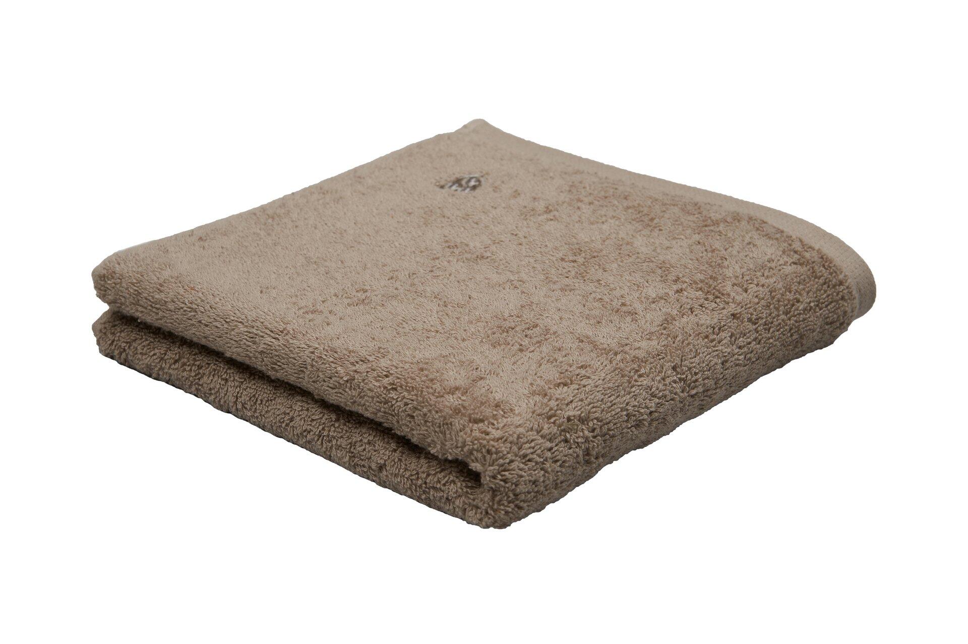 Flauschiges Beige-Handtuch Vita aus 100% Baumwolle, seitlich auf einer weißen Unterlage dargestellt, um die Textur und Dicke hervorzuheben.