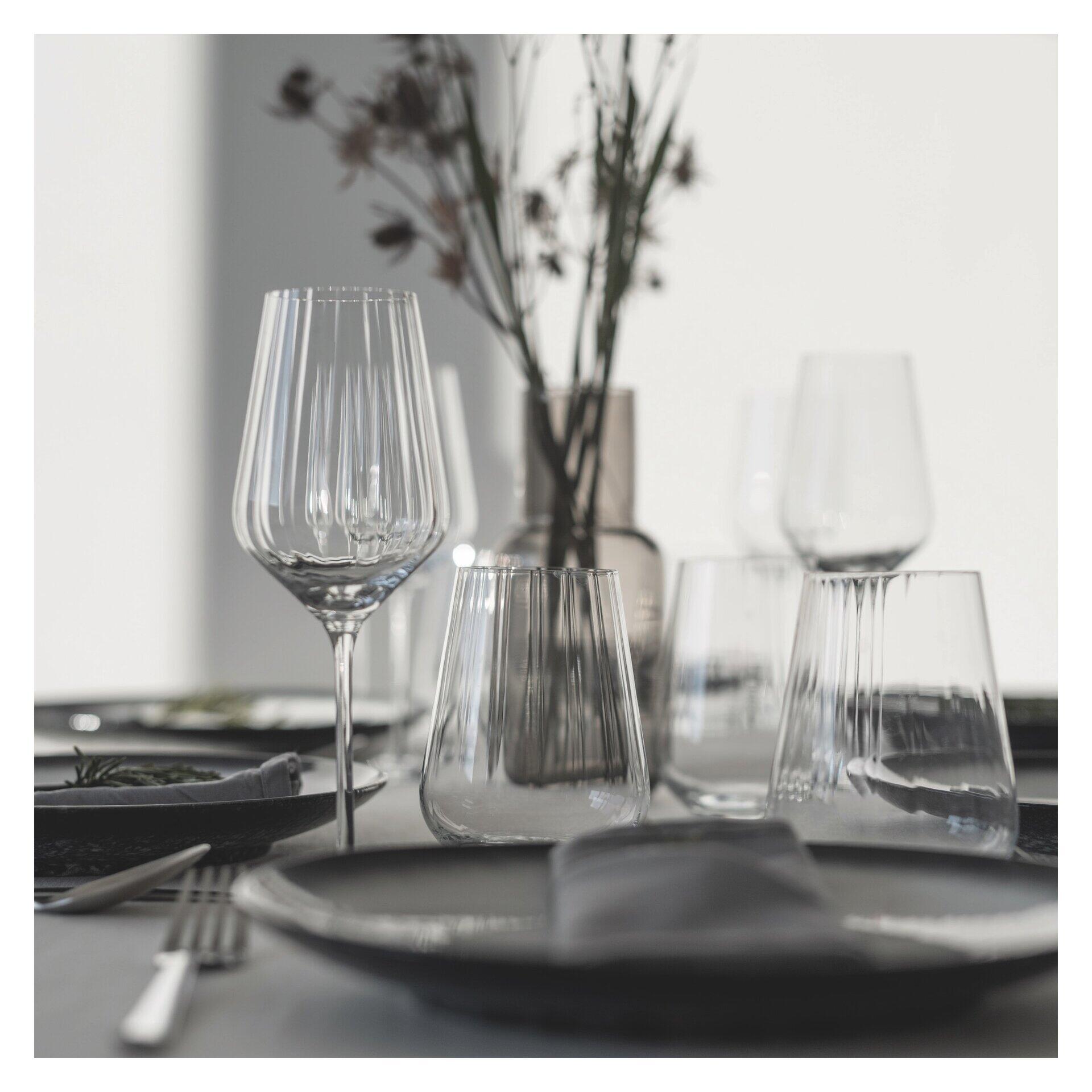Wasserglas-Set mit Reliefstruktur, dargestellt in stilvoller Tischdekoration mit verschiedenen Glasformen und einer erhöhten Perspektive.