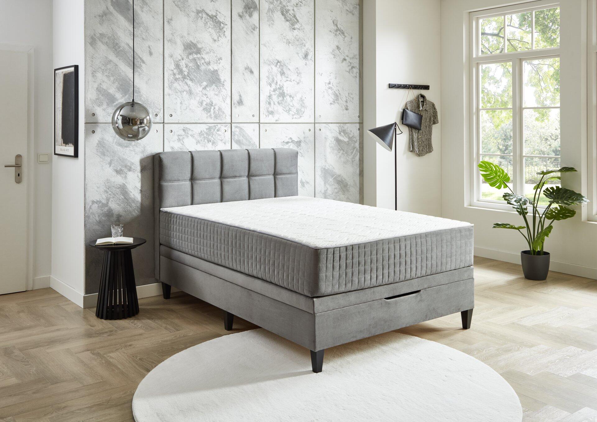 Boxspringbett Wien BX2590 mit grauem Samt-Kopfteil und integriertem Bettkasten, aus erhöhter Perspektive in einem stilvollen Schlafzimmer.