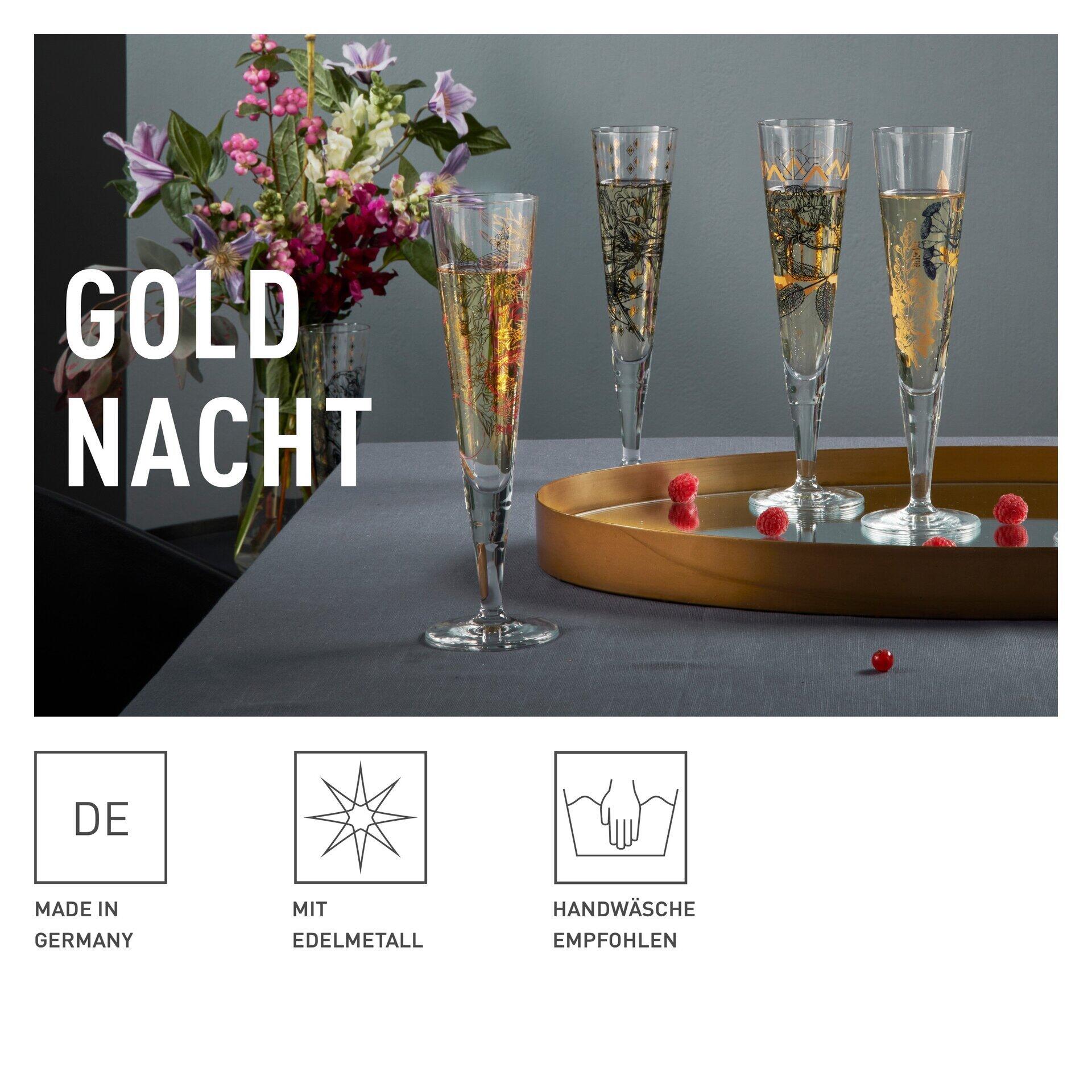 Drei schmale, hoch aufragende Champagnergläser mit goldenem Farbton in einer attraktiven Geschenkbox, präsentiert auf einer gewölbten Oberfläche mit verschwommenem Hintergrund aus roten Hibiskusblüten und Blättern.