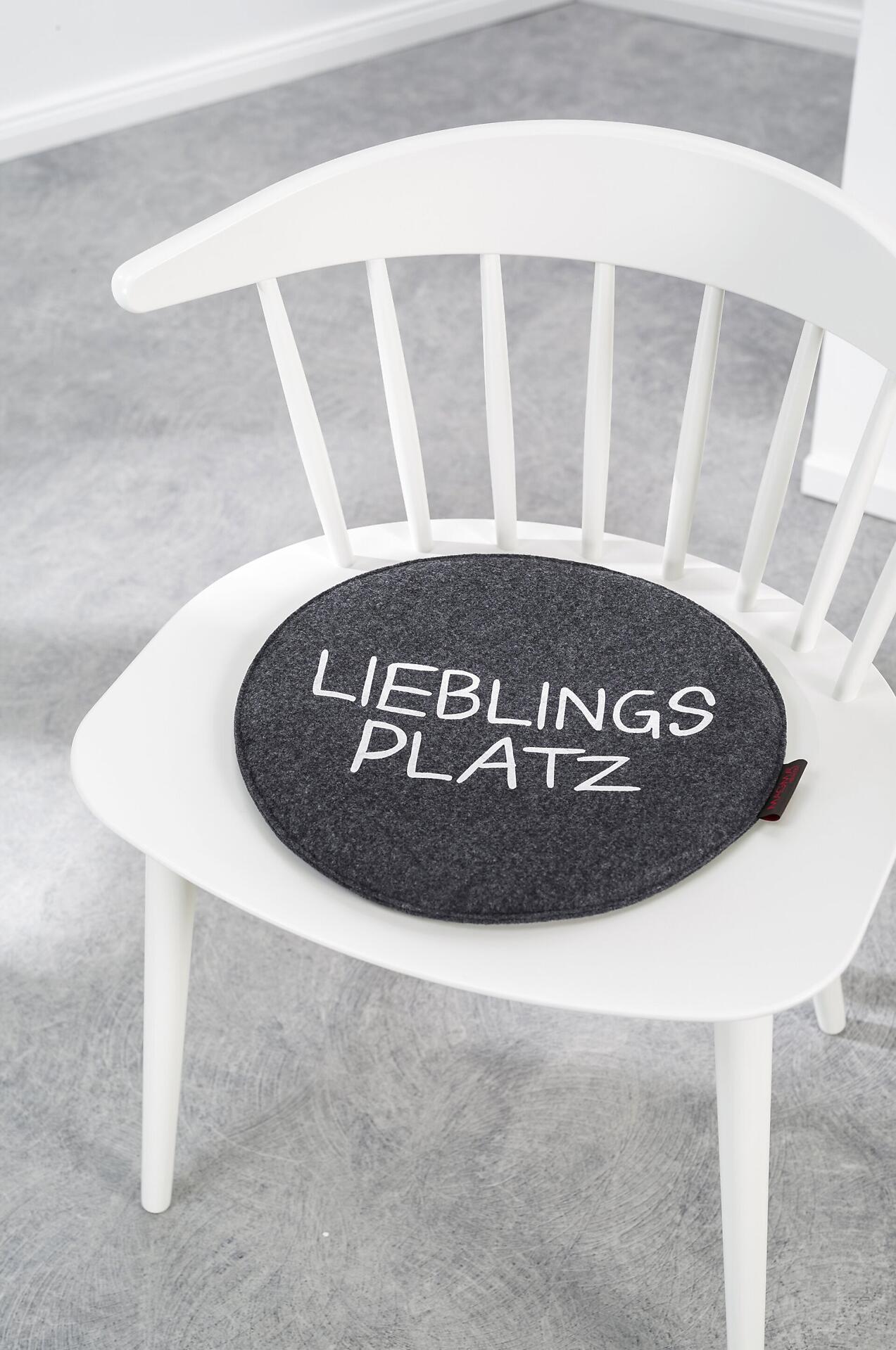 Sitzkissen "Lieblingsplatz" in Anthrazit auf einem skandinavischen Stuhl, das durch seine Polsterung zusätzlichen Komfort und ein dekoratives Element bietet.