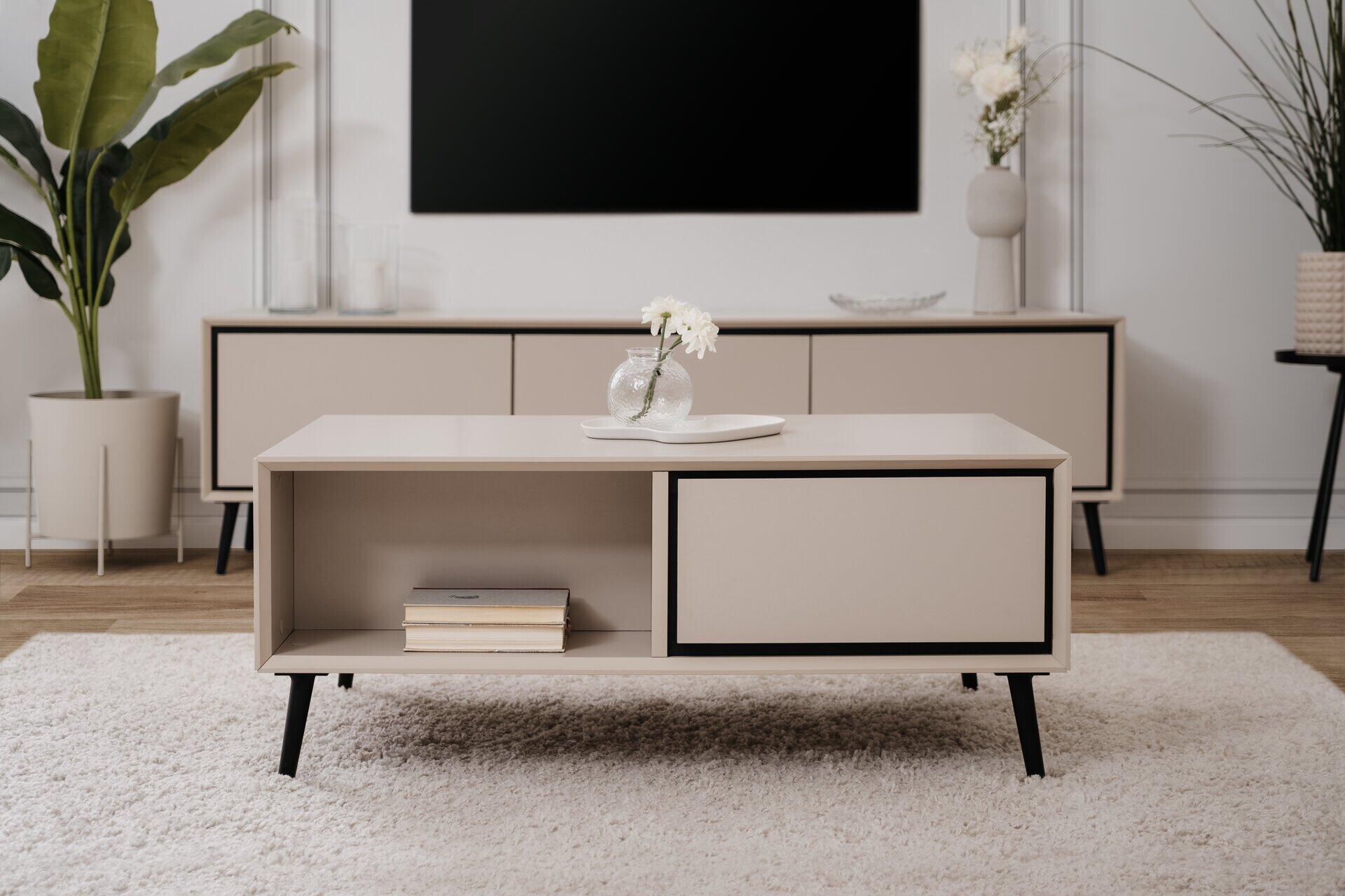 Couchtisch Arona 55A mit Schublade, offener Nische und rundem Fuß, präsentiert aus leicht erhöhter Perspektive auf einem Teppich.