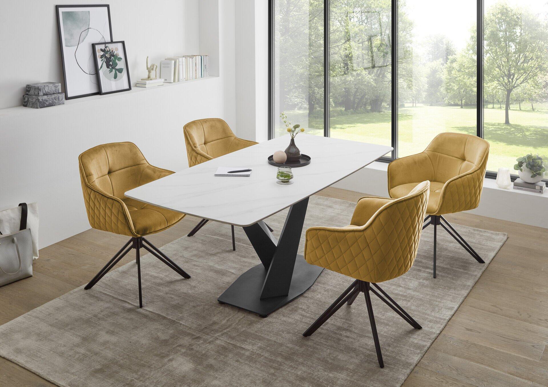 Modernes Esszimmer mit weißem Tisch, gelben Sesseln und dekorativer Wandregalanlage.