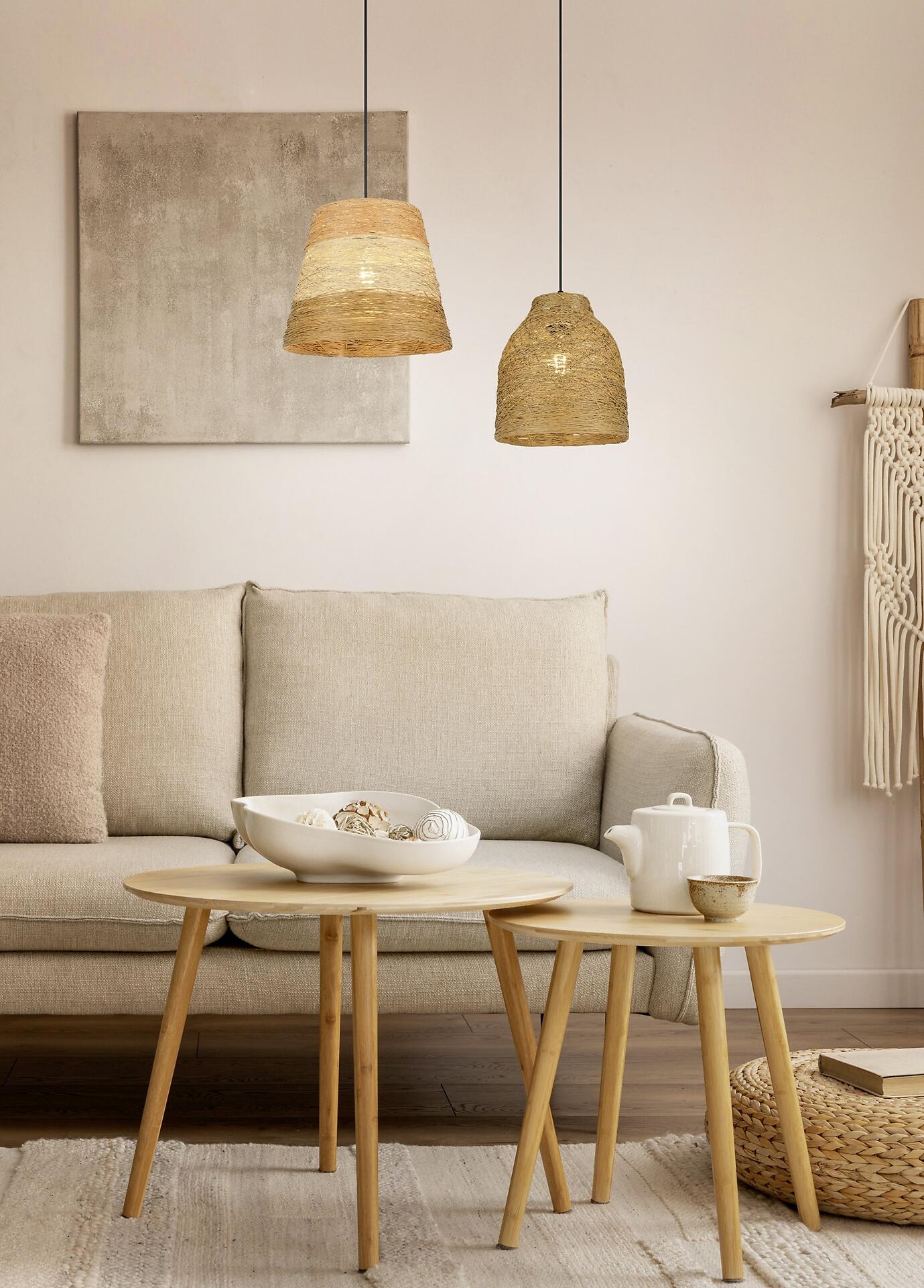 Pendelleuchte Joeline aus Bast oder Rattan, die über einer graubeigen Couch in einem skandinavisch eingerichteten Wohnbereich hängt.