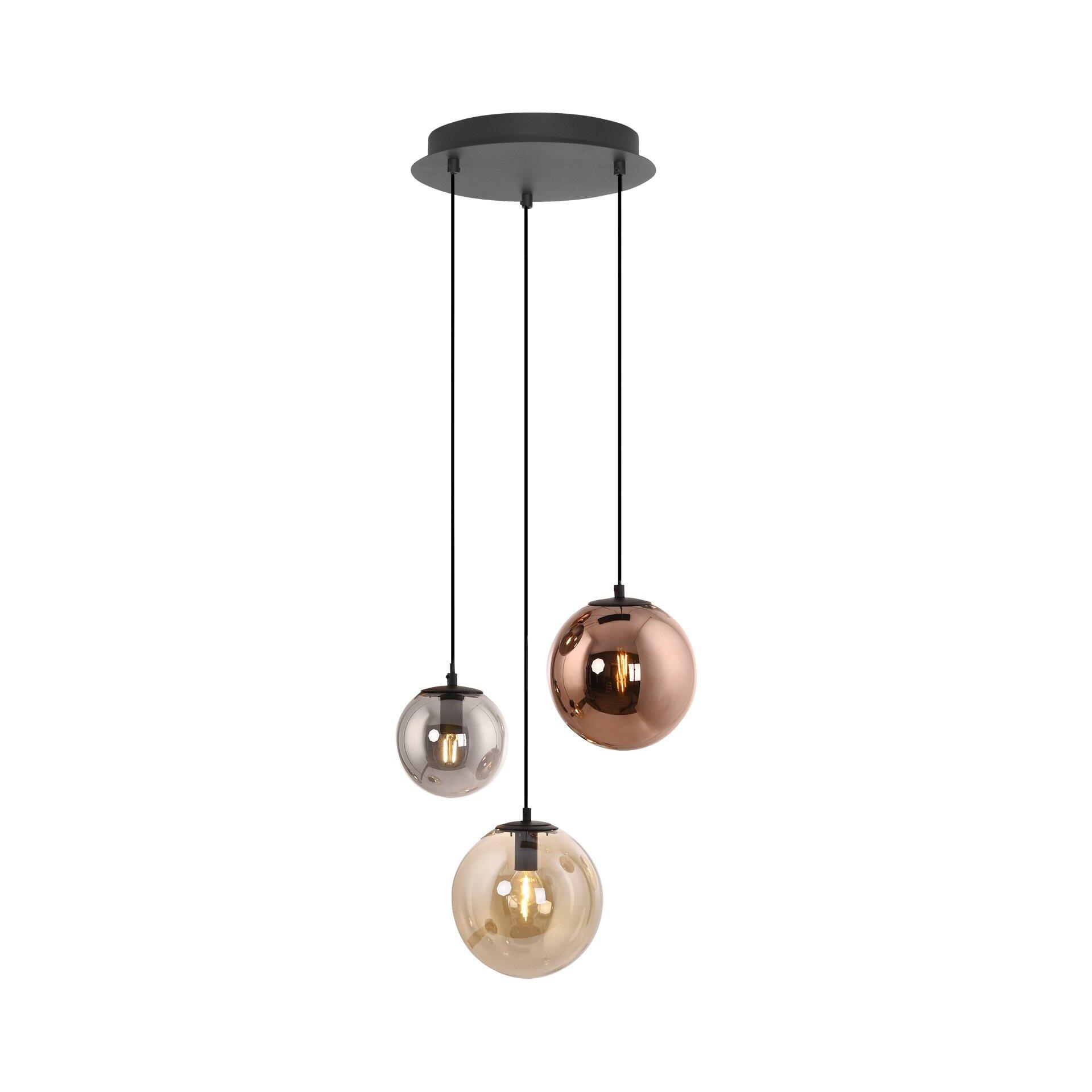 Moderne Pendelleuchte Shiny mit drei farblich abgestuften Kugeln (silbergrau, kupferfarben, goldgelb) an schwarzen Kabeln, die von einem schwarzen Deckenzapfen hängen und warmes Licht abstrahlen.