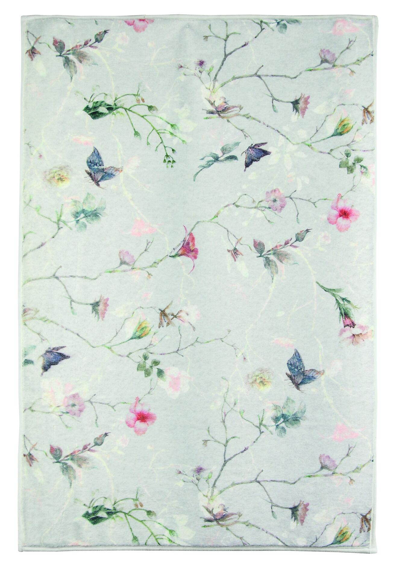 Nahaufnahme des floralen Musters des multicolor Badteppichs Flores mit Blüten, Blättern, Ästen und kleinen Schmetterlingen auf einem pastellgrünen Grund.