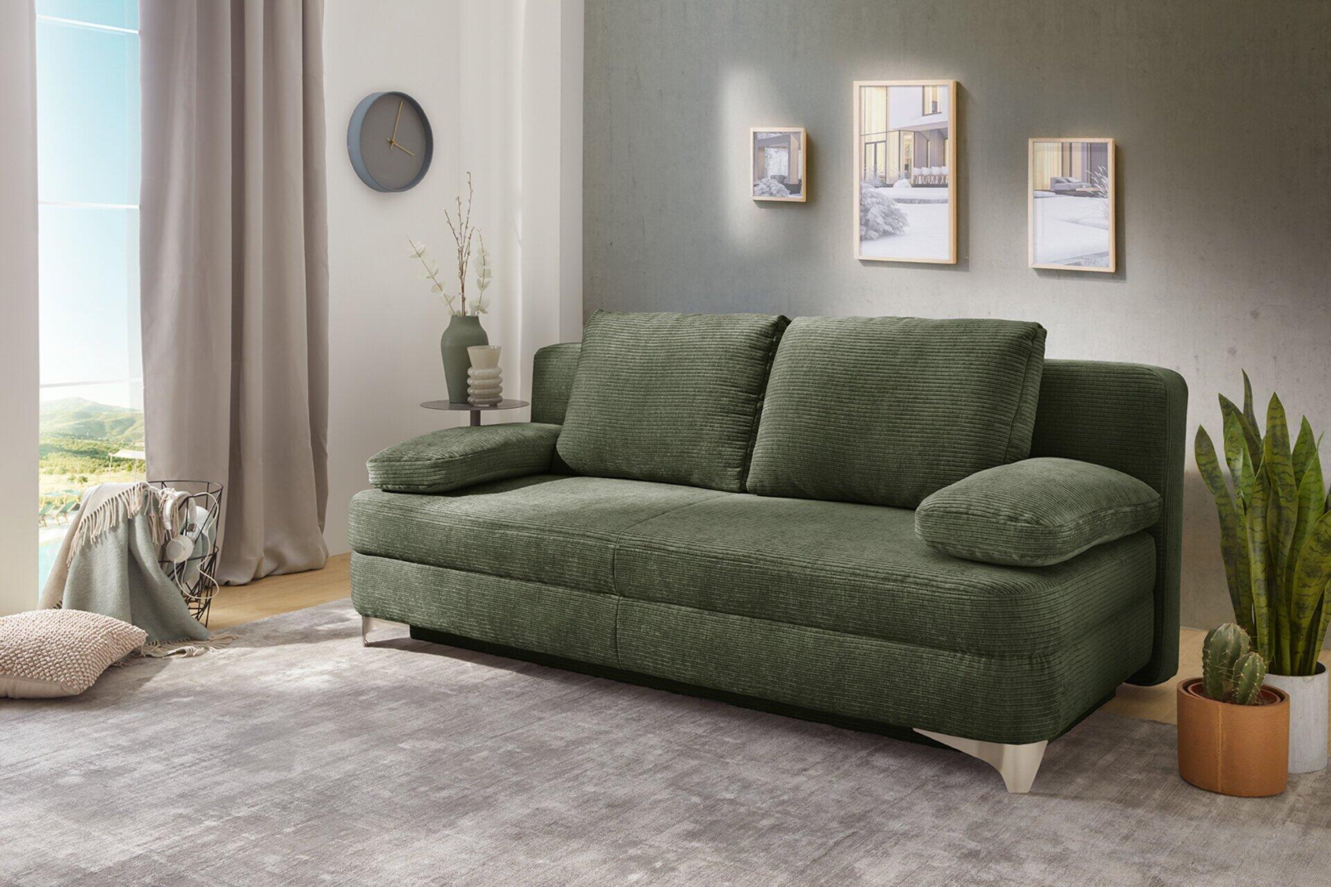 Dunkelgrünes Schlafsofa Noah mit Relax-Funktion, abgebildet in einer hellen Wohnumgebung mit geschwungener Form und hohen Armlehnen.