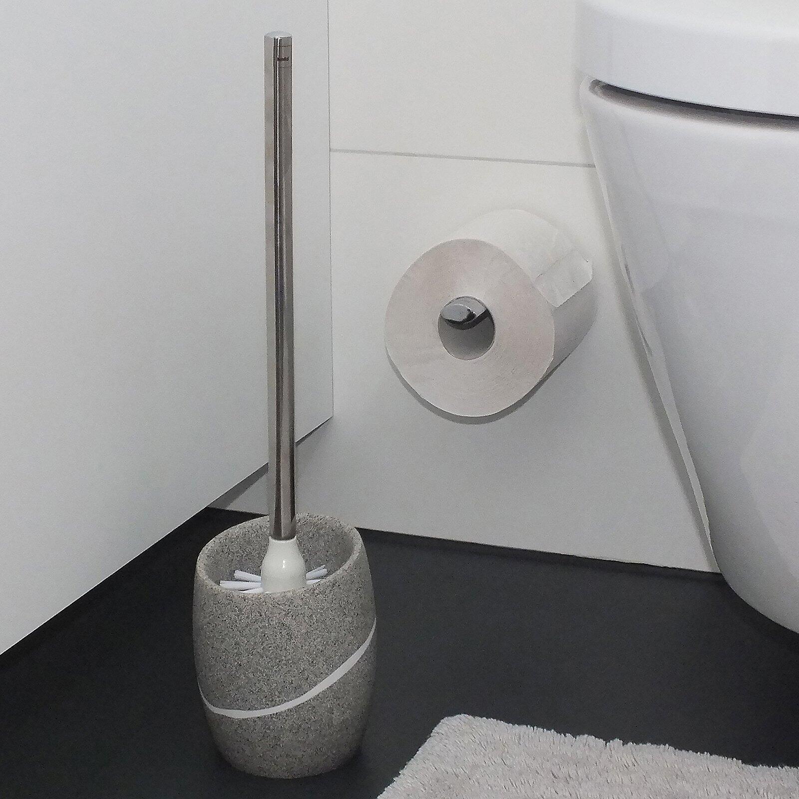 Toilettenbürste Talus mit grauer Keramik-Basis und silberfarbenem Stiel, leicht von unten fotografiert, im Badezimmerambiente.