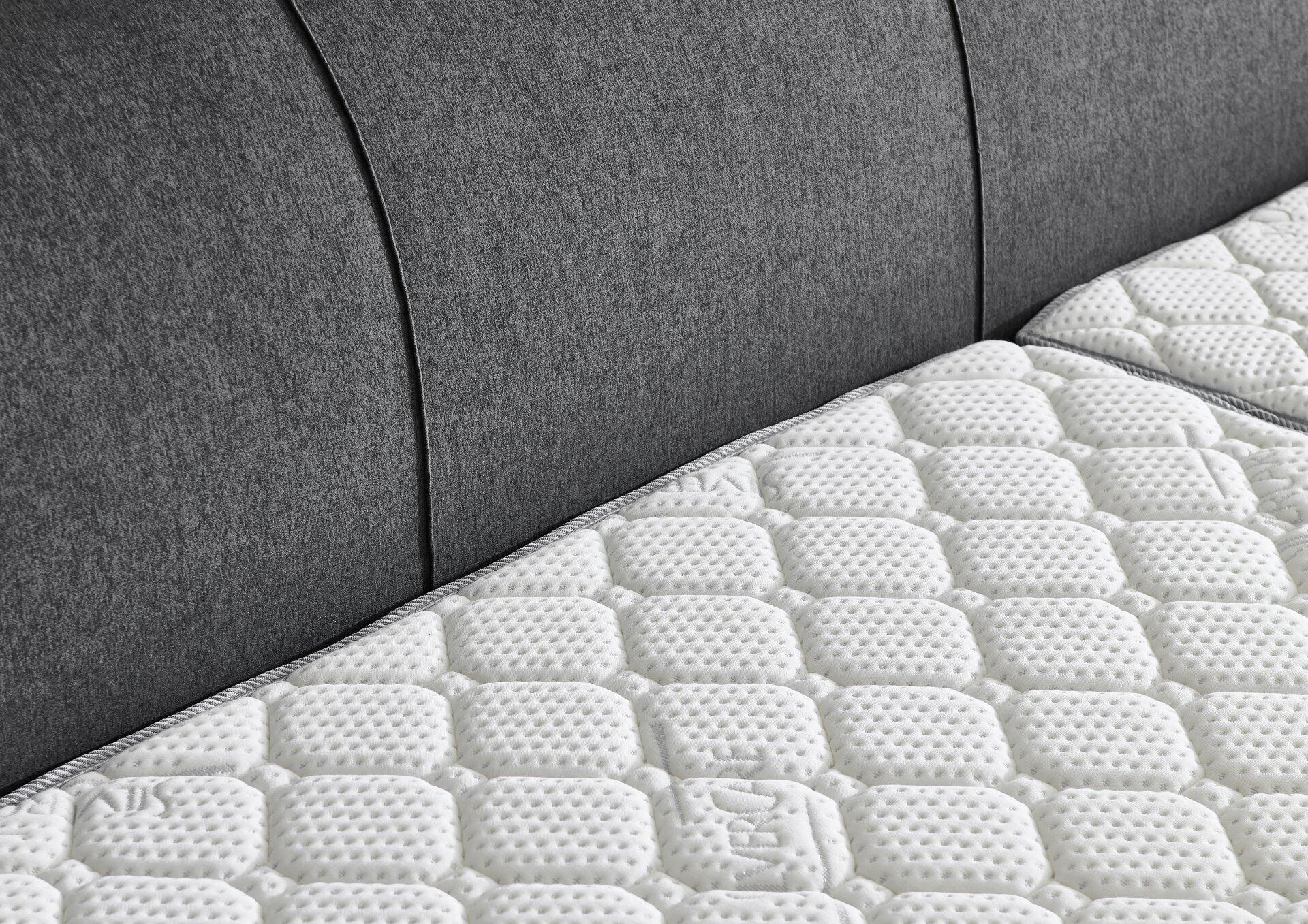 Detailaufnahme des Kopfendes des Boxspringbettes Modesto BX1440 mit quiltgestopfter Oberfläche und strukturiertem, grauem Bezug.