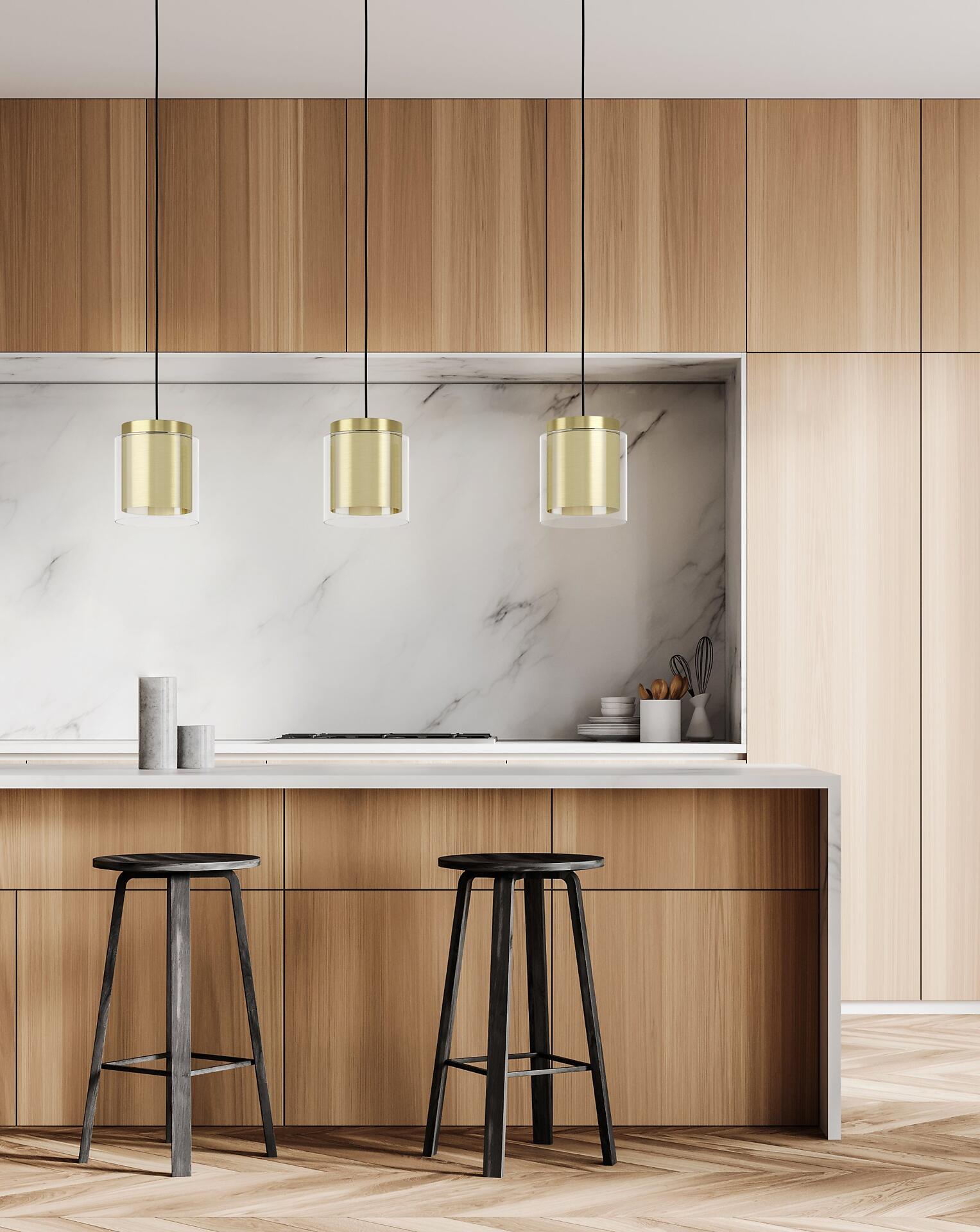 Drei goldene Pendelleuchten der Modellreihe Lagunitas, mit klarem Glas, beleuchten stilvoll eine moderne Kücheninsel mit Marmorbar und Holzschränken.