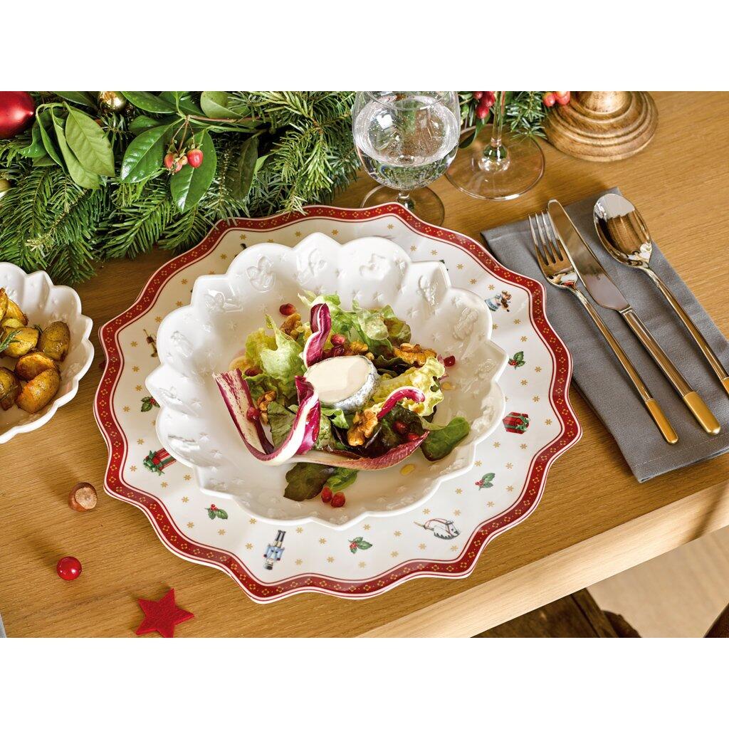 Weißer Speiseteller Toy's Delight mit festlichem Weihnachtsmotiv und goldenen Akzenten, gefüllt mit Salat, präsentiert auf einer festlich gedeckten Tafel mit Besteck und Weinglas.