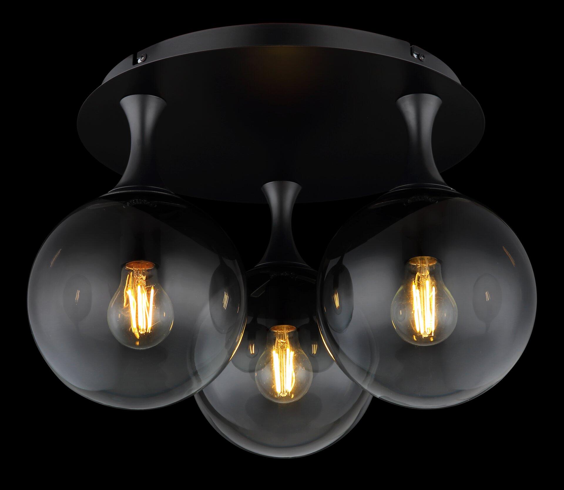 Deckenleuchte DALTON mit drei schwarzen Glaskugeln, die von oben gefilmt und durch ihre teilweise transparente Struktur das warme Licht der Edison-Glühbirnen hindurchscheinen lassen.