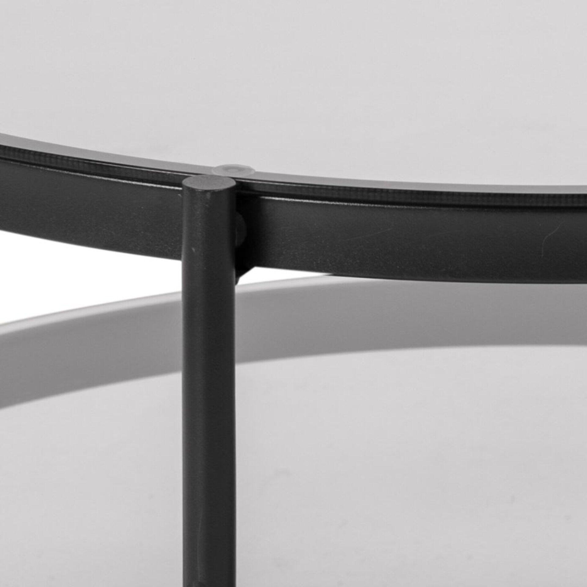 Couchtisch Bayonne: Detailaufnahme eines schwarzen Metallgestells mit Drahtkörbeinsatz, das die runde Form und die Verbindung der vertikalen Stäbe zeigt.