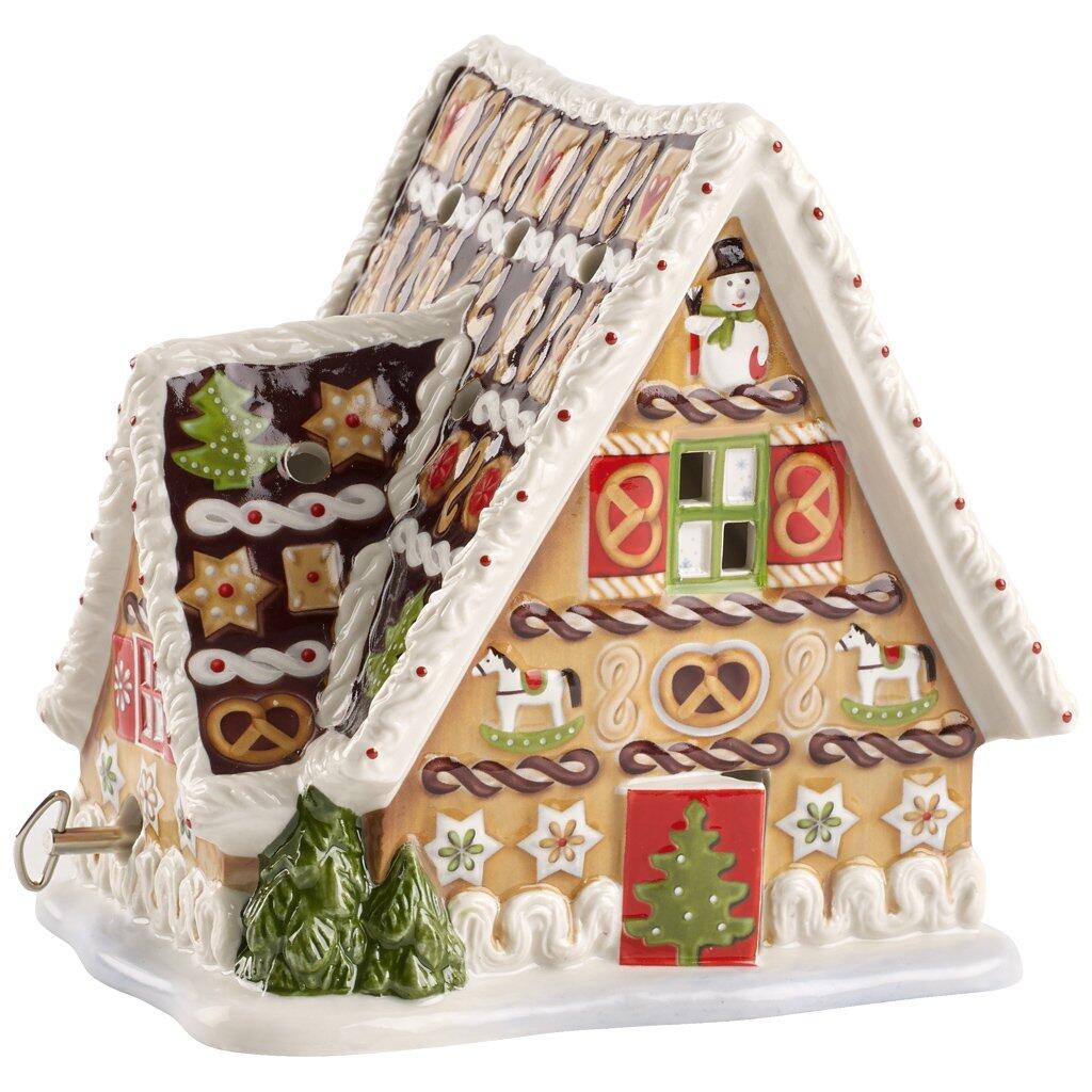 Detailreiches Lebkuchenhaus mit aufwendiger Zuckerglasur, Zuckerstangen, Lebkuchenherzen und Schneeflocken auf dem Dach, aus der ¾-Perspektive erkennbar.