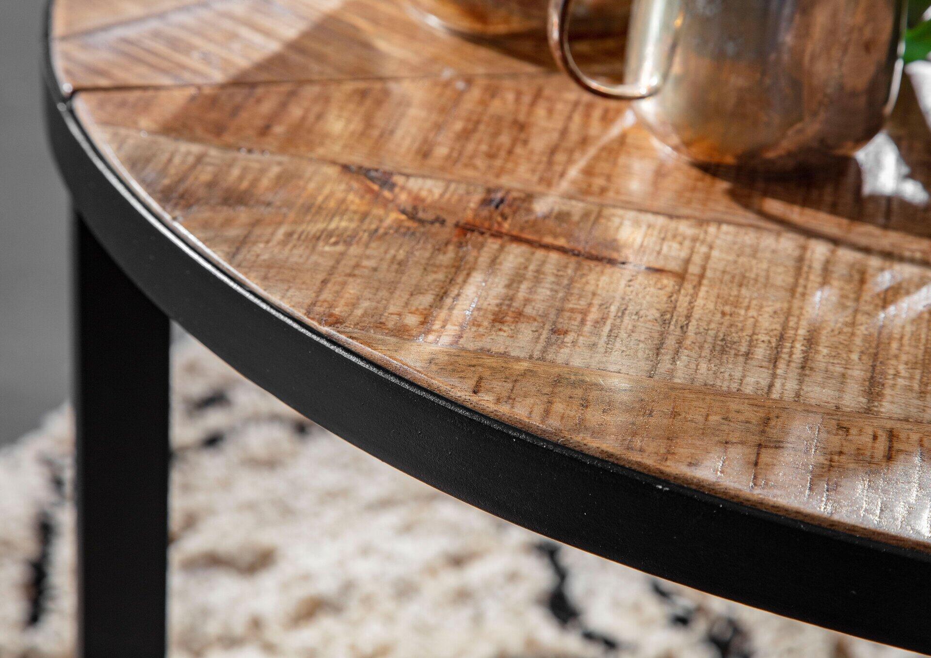 Detailaufnahme des Couchtisches 4061915182416 mit gebeizter und lackierter Holzplatte, schwarzer Metallkante und filigranem, mehrteiligen Metallfuß.
