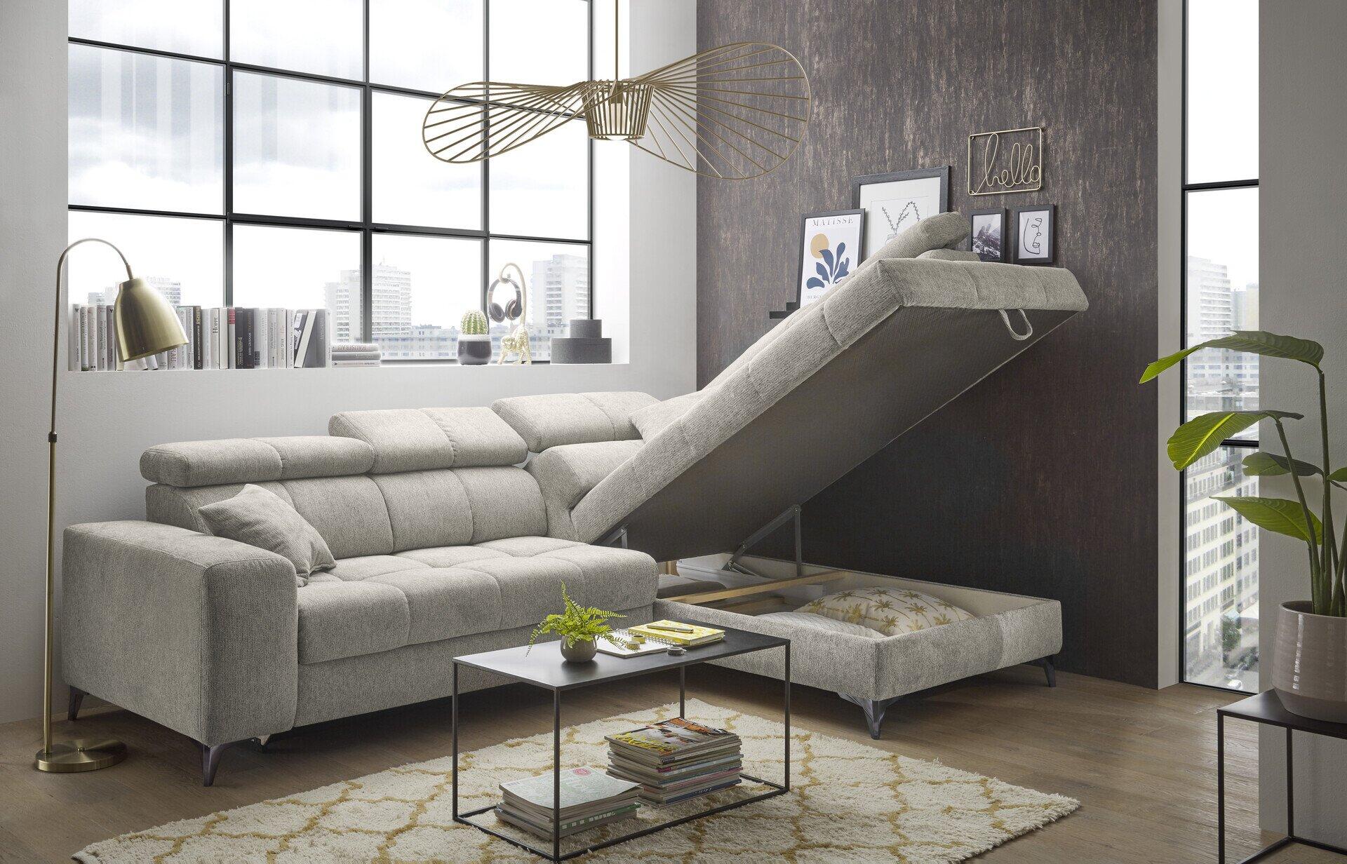 Helles Ecksofa Sydney mit integriertem Ausziehbett und dekorativem Strickelement, leicht erhöht fotografiert in einem modernen Wohnzimmer.