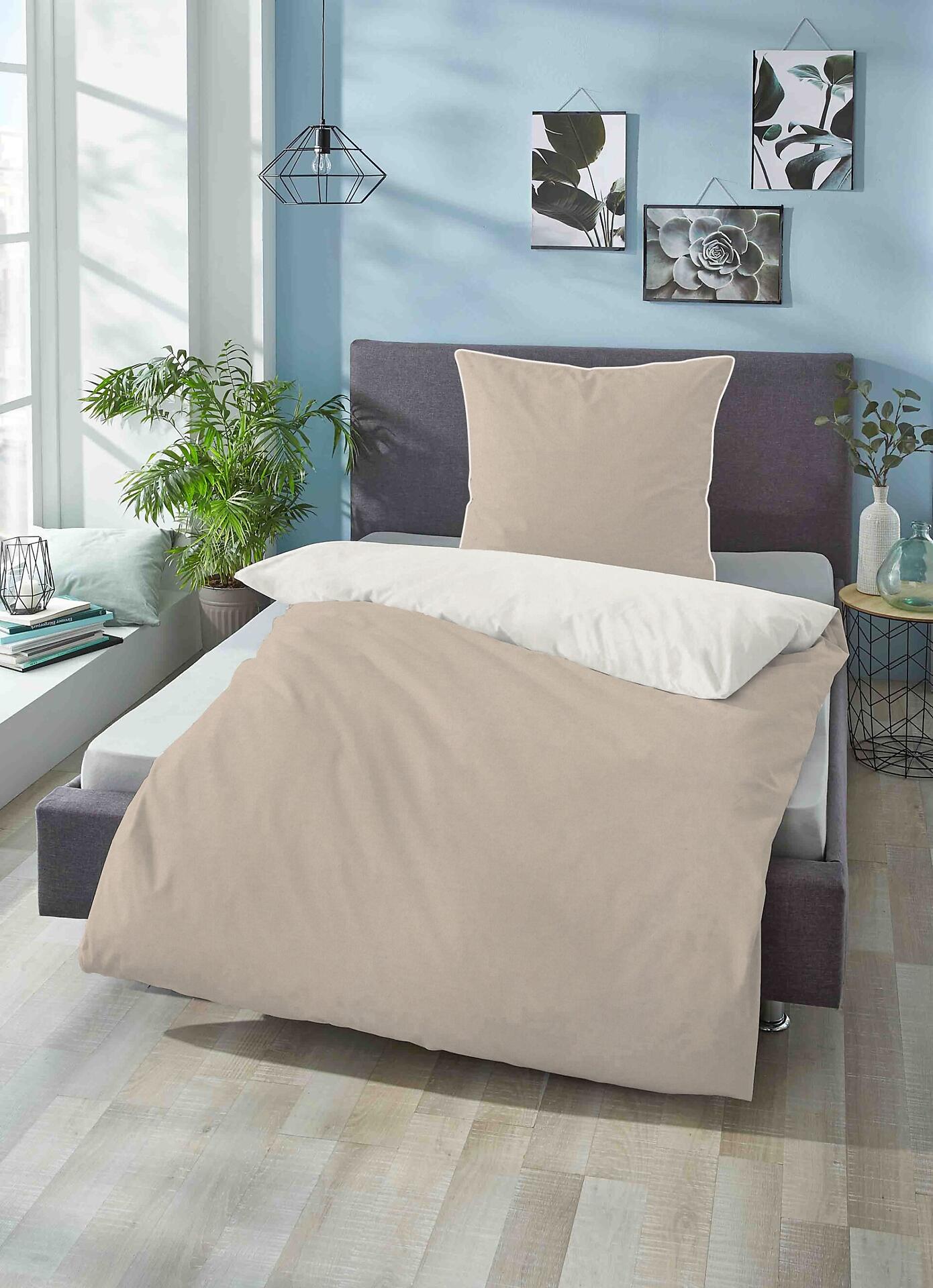 Bettgarnitur Biberna mit hellem Bettbezug und grauem Rahmen in einem stilvoll eingerichteten Schlafzimmer, leicht erhöhte Perspektive zeigt das Gesamtbild des Bettes und einen Teil des Raumes.