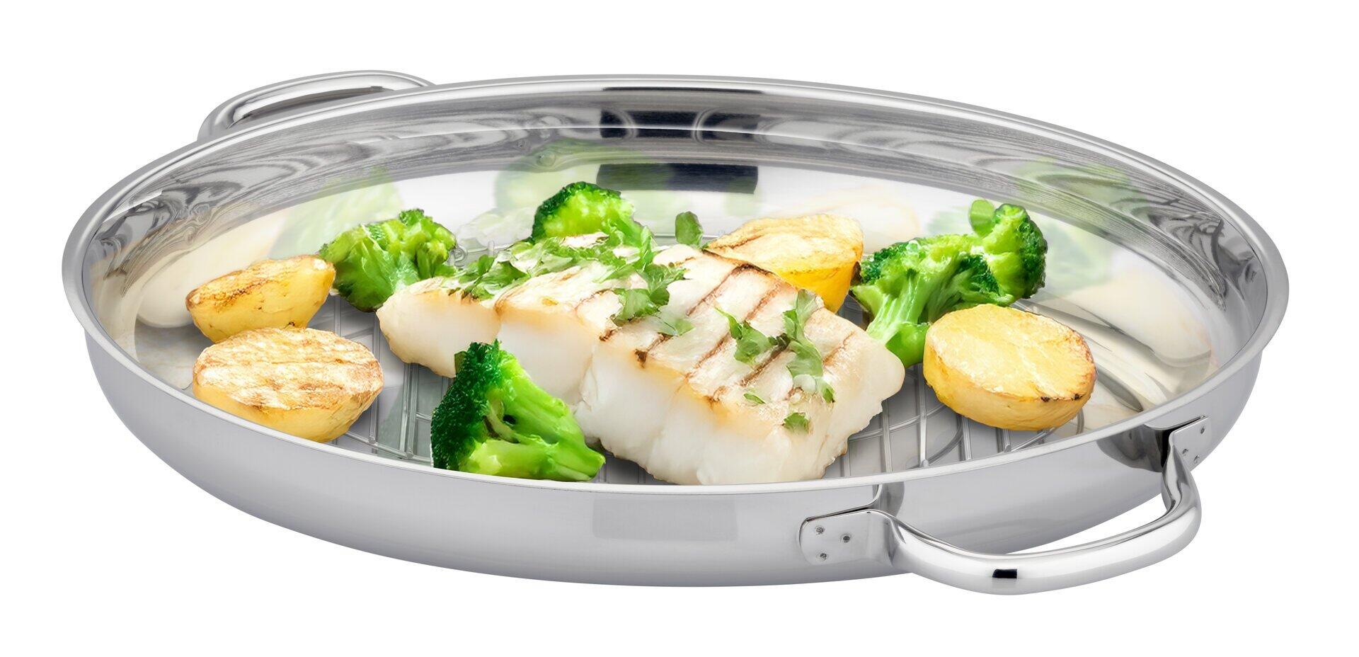 Edelstahl-Bräter Lafer mit transparentem Deckel, Dünst- und Grilleinsatz und integrierten Erhebungen für schonende Zubereitung, gefüllt mit gegrilltem Fisch, Kartoffeln und Broccoli.