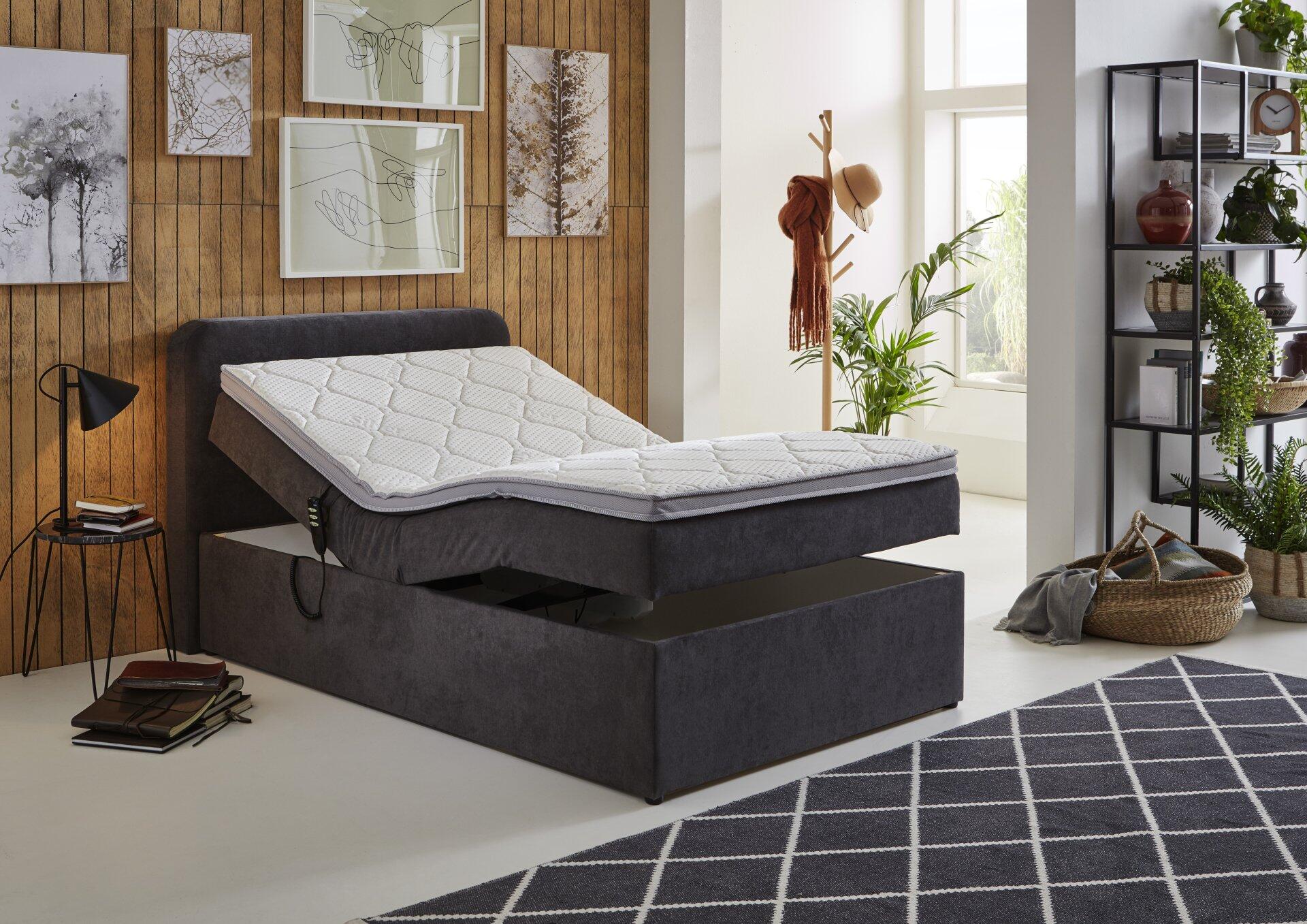 Boxspringbett Gabriola BX1880 mit grauem Stoffbezug und motorischer Verstellung, die den Oberkörperbereich für mehr Komfort anhebt.