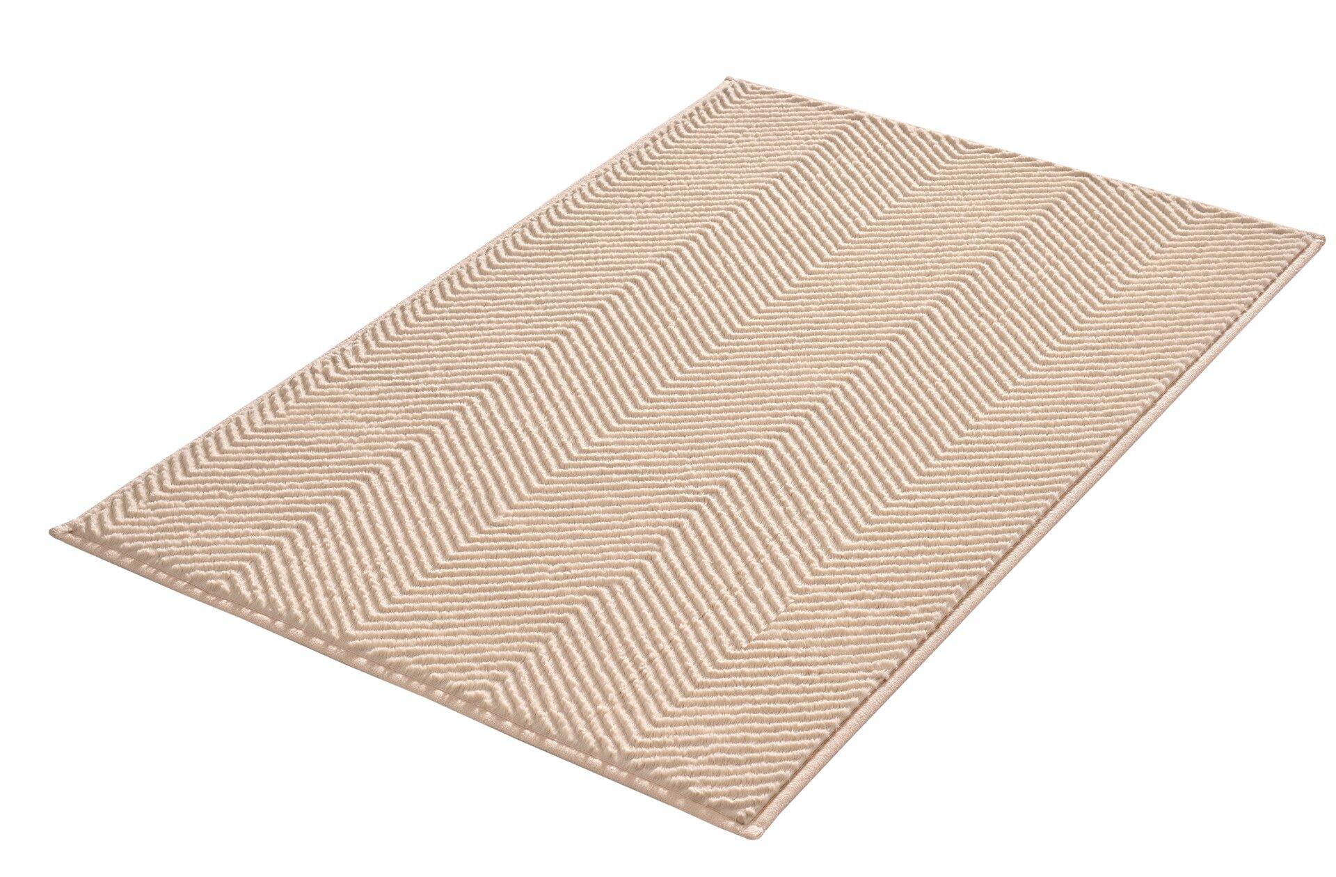 Badteppich Zigzag: Sandbeiger Teppich mit diagonalem Streifenmuster, aus der Vogelperspektive fotografiert.