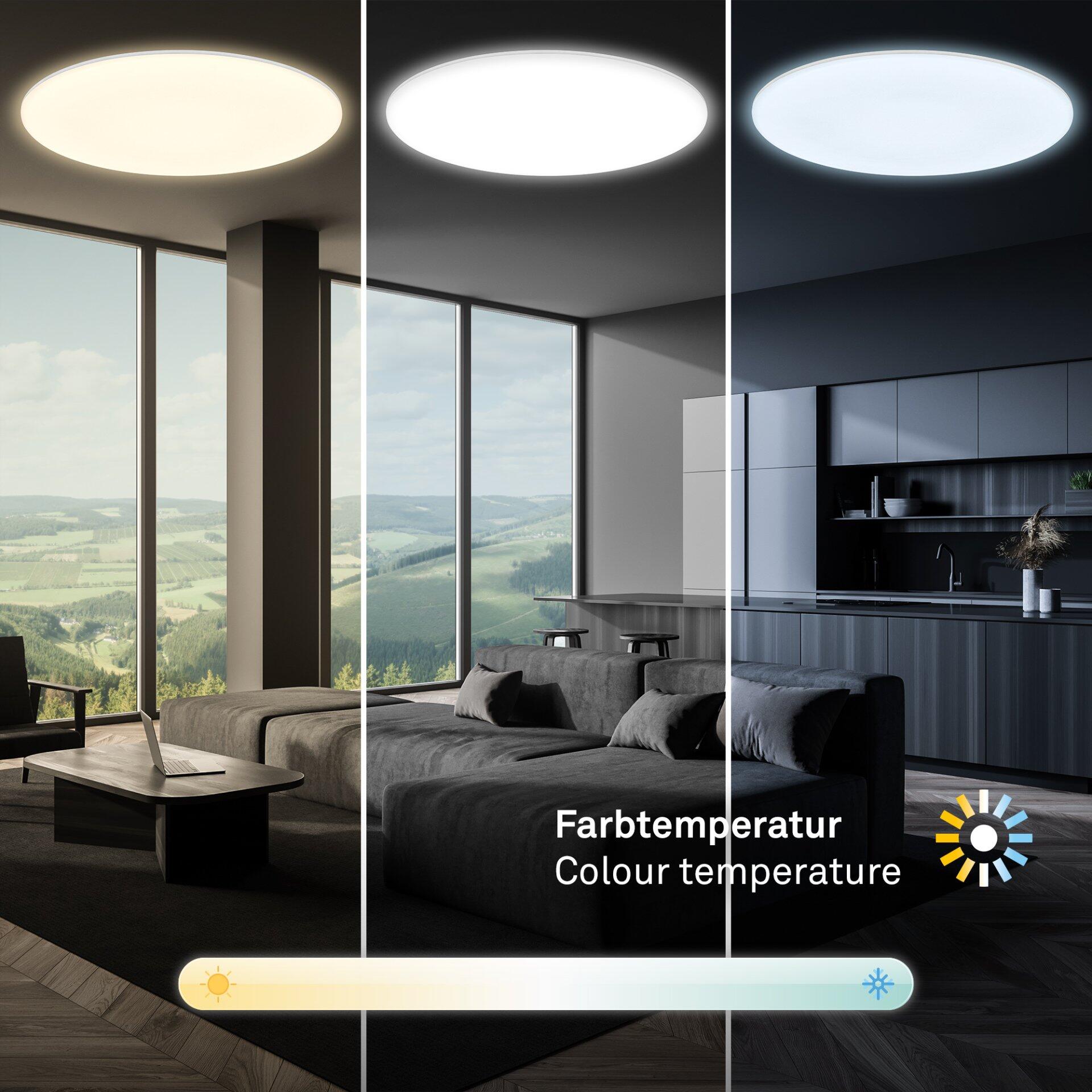 Runde Wand- und Deckenleuchte Rowny mit warmweißem Licht, integriert in ein modernes Wohnzimmerambiente mit Couchsofa und Blick auf eine grüne Landschaft.