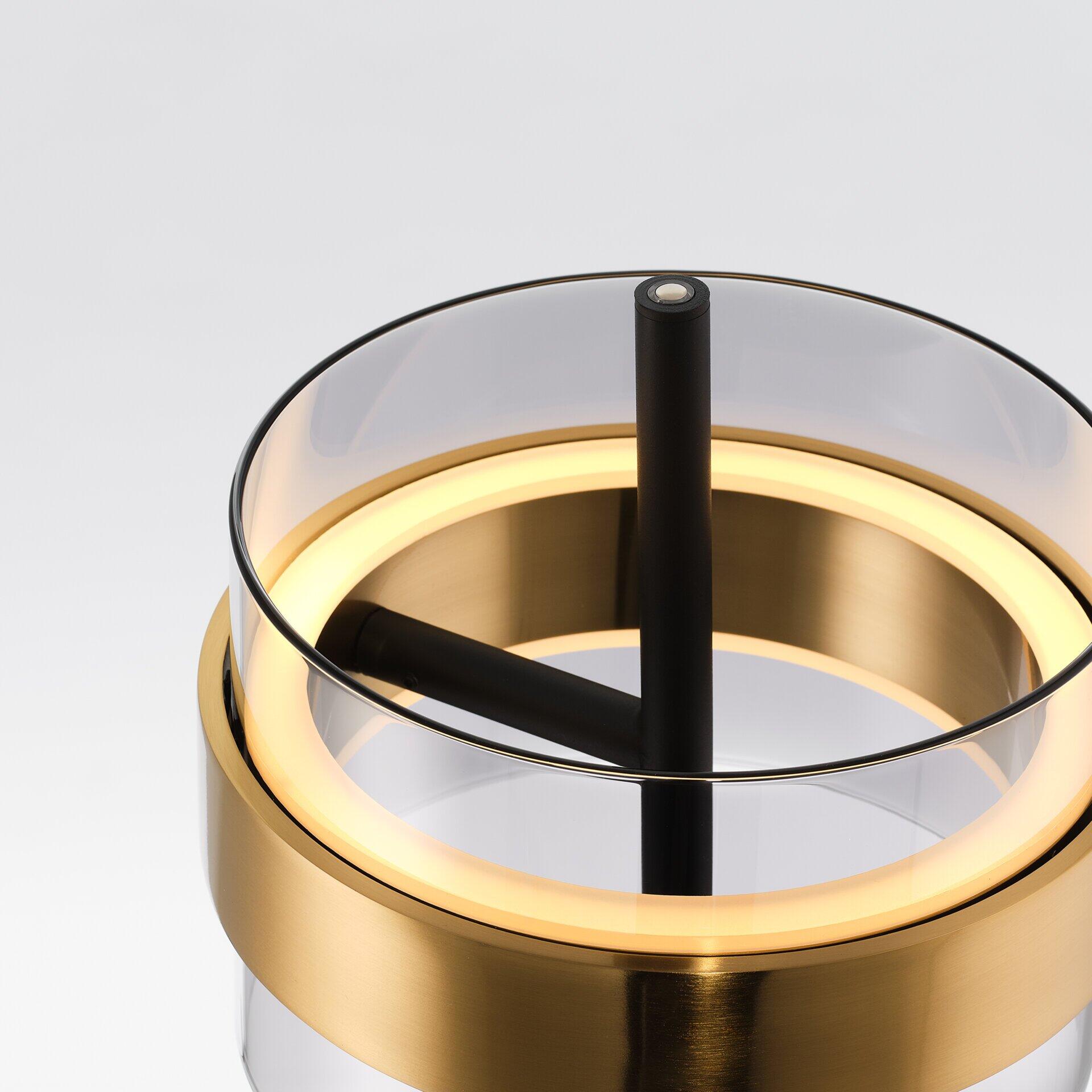 Tischleuchte Inside mit goldenen Akzenten und Touchdimmer, dargestellt in einer Nahaufnahme aus leicht unterer Perspektive, die den eleganten Glasfuß, den goldenen Ring und den warmen Lichtschein betont.