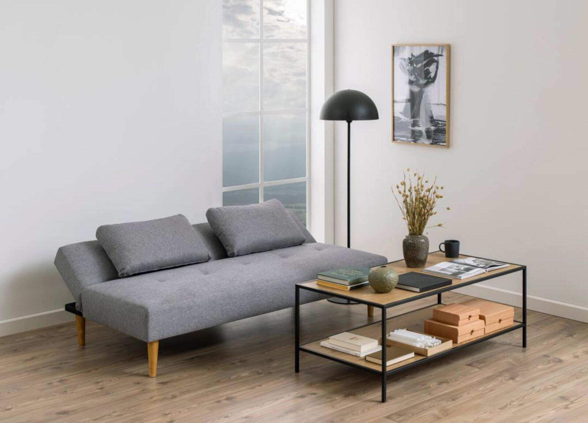 Bettcouch Lucca im modernen Design mit integrierter Schlaffunktion und passendem Couchtisch, leicht seitlich aus Augenhöhe fotografiert.