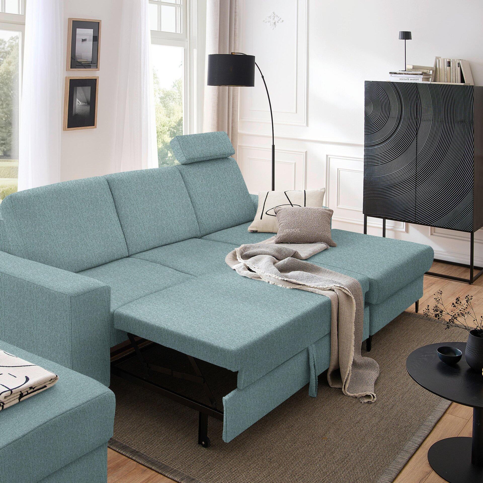 Ecksofa Balina in helblau-grün mit Metallfüßen und herausziehbarer Schlaffläche, leicht seitlich aufgenommen, um Design und Form zu betonen.