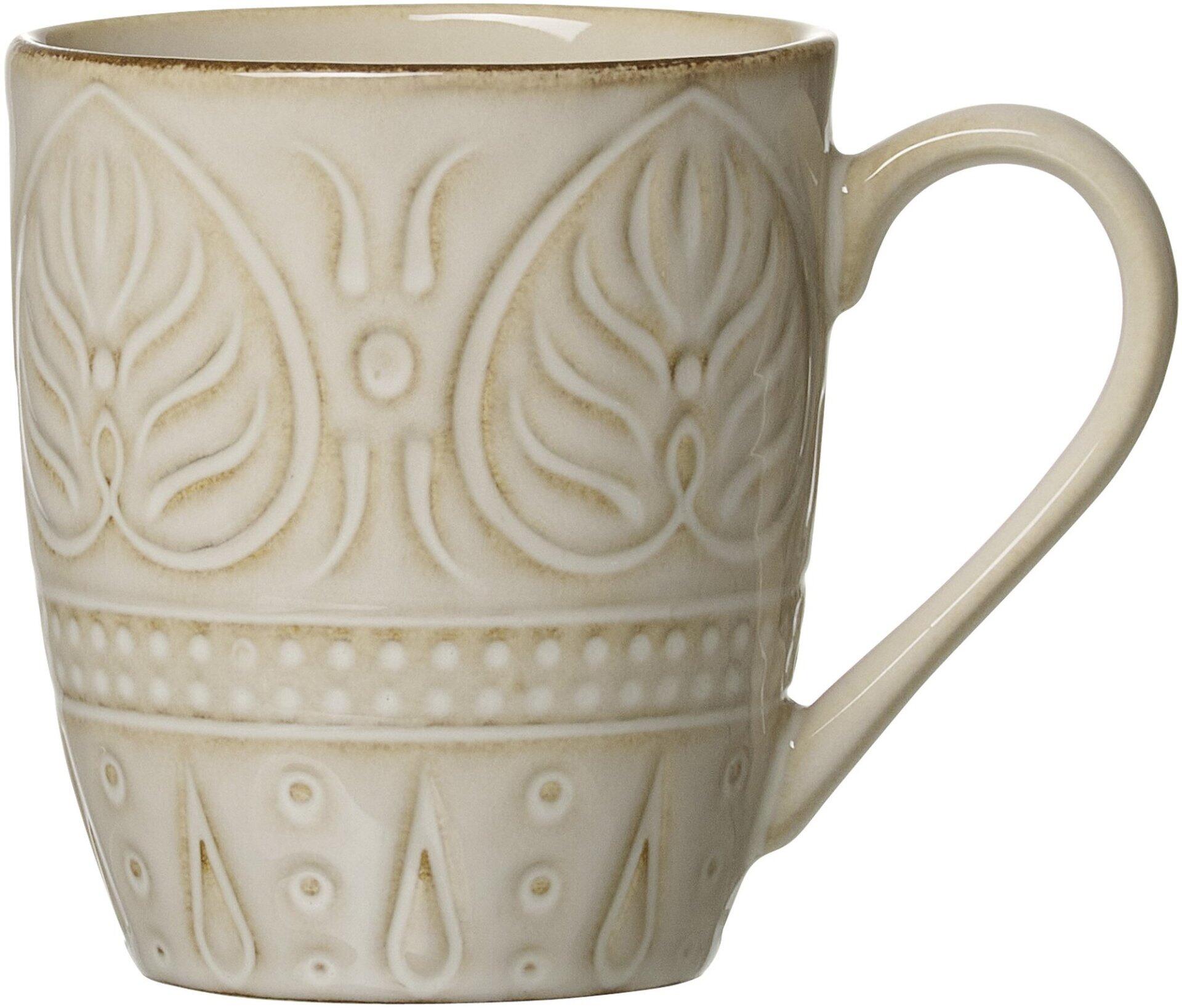 Beige Omara Becher von Ritzenhoff & Breker mit reliefartigen Blütenmotiven und geschwungenem Henkel im Detail.