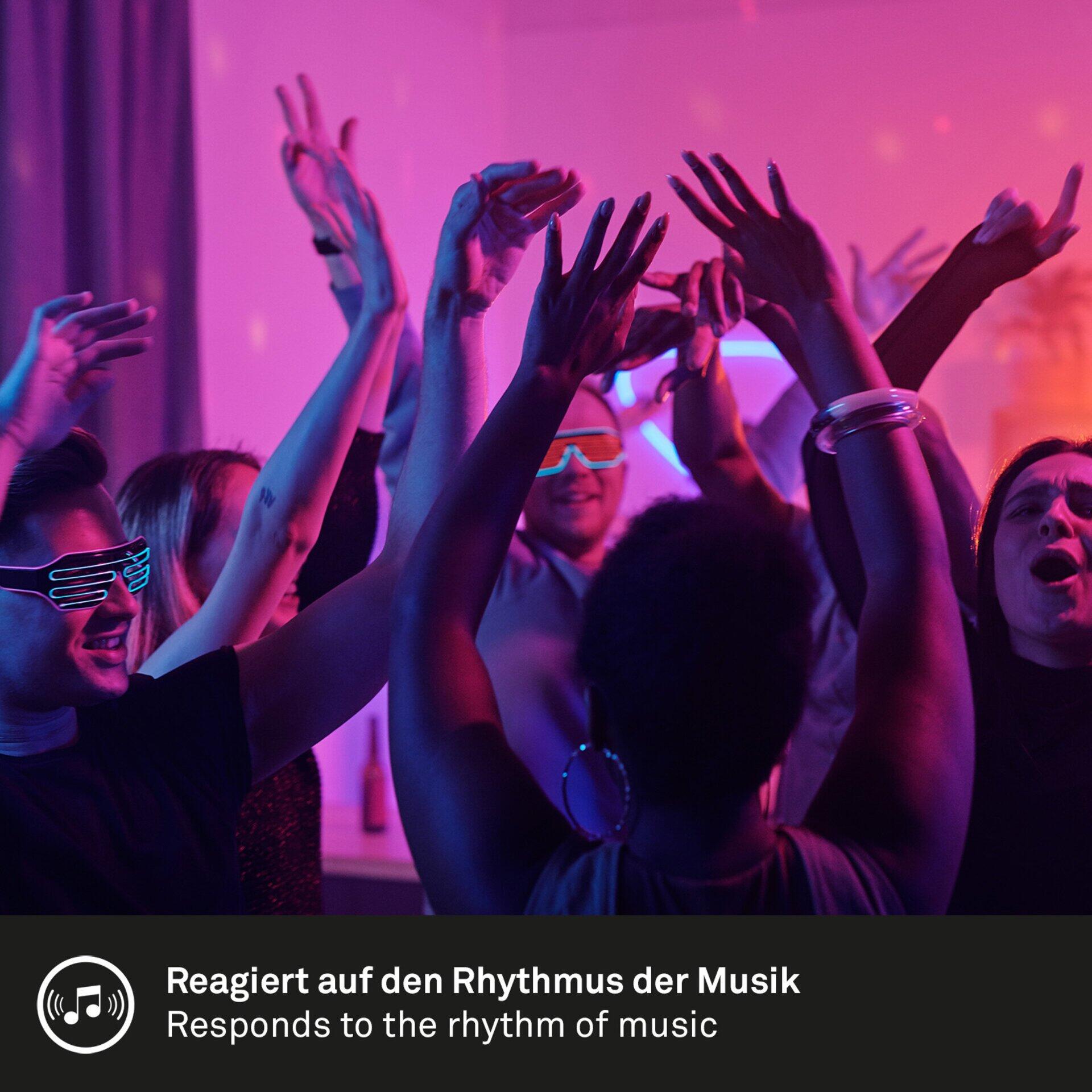 Energiegeladene Stimmung bei einer Musikveranstaltung mit farbigem Licht in Rot und Lila.