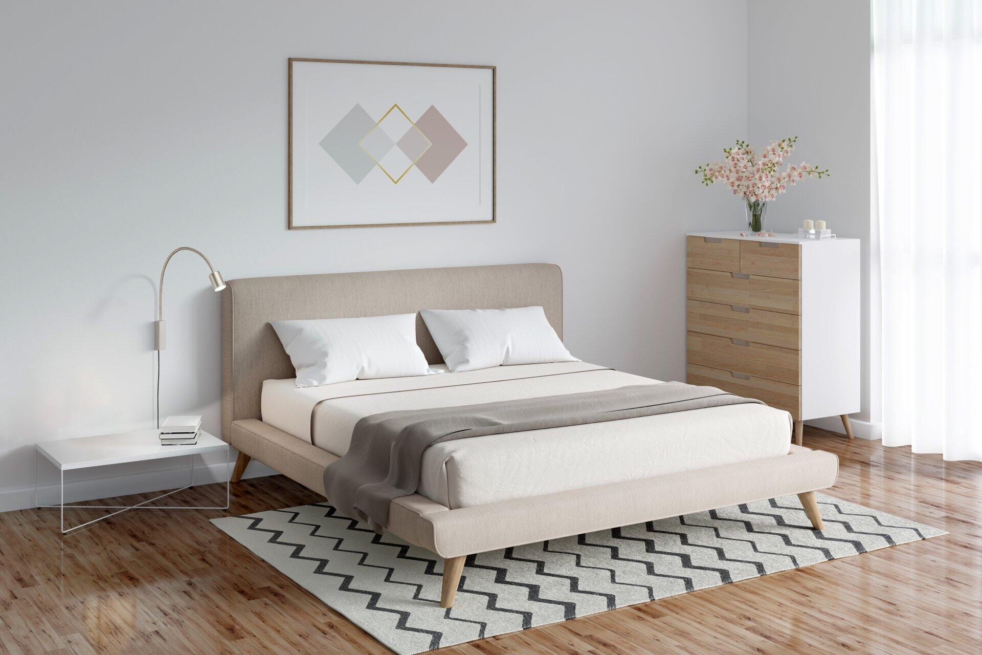 Bettleuchte Flex, Justi, schaltbare Nachttischlampe mit silbernem Finish, integriert in ein modernes Schlafzimmer mit grauem Bett und hellem Teppich.
