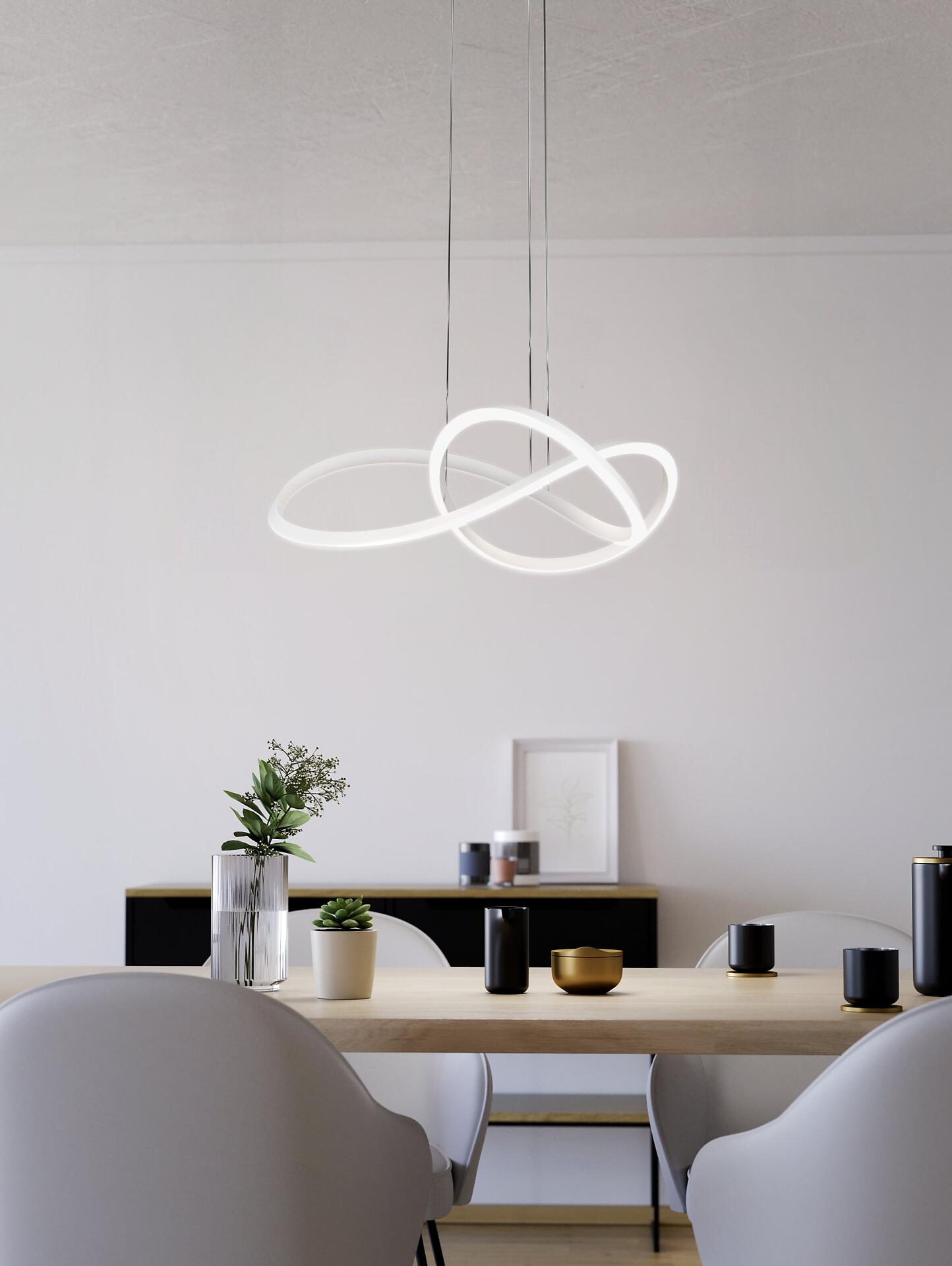 Moderne LED-Deckenleuchte Riaza im Esszimmer, dargestellt als zwei ineinander verschlungene Ringe, die warmweißes Licht ausstrahlen.