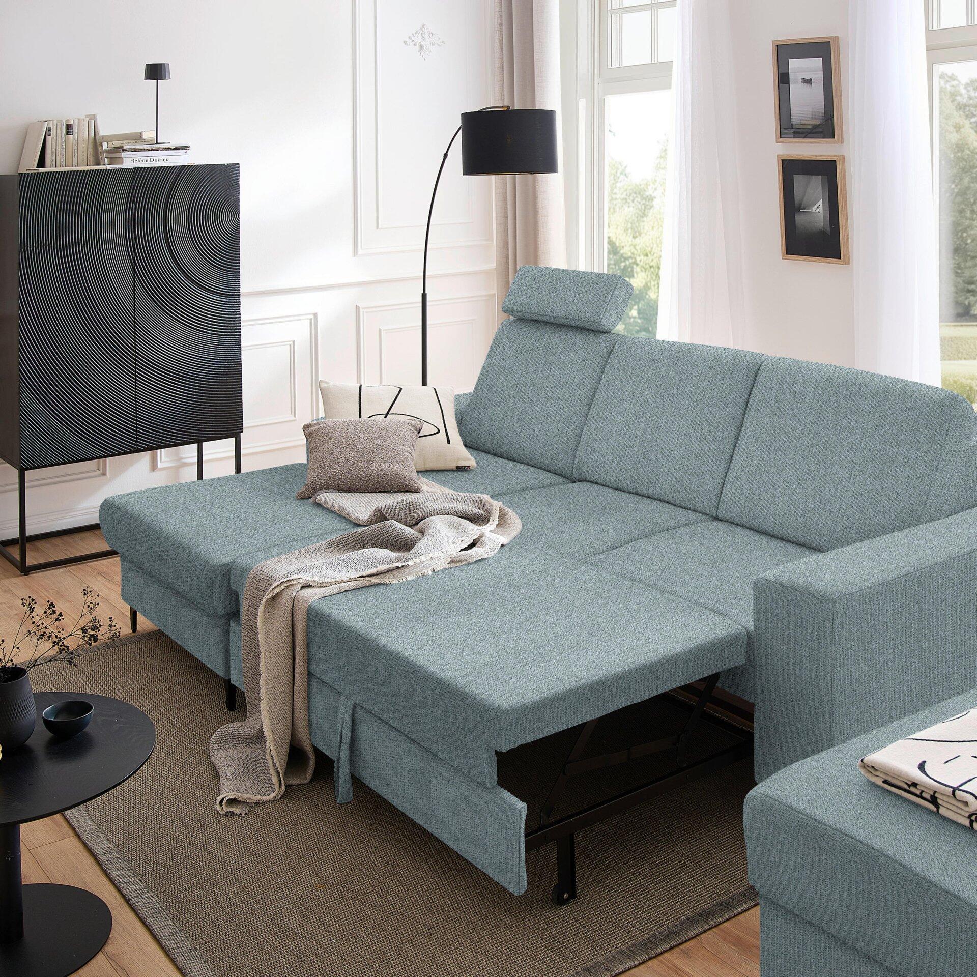Ecksofa Balina in hellblau-grau mit ausgeklappter Schlaffunktion und Bettkasten, abgebildet aus leicht schräger Perspektive im modernen Wohnzimmer.