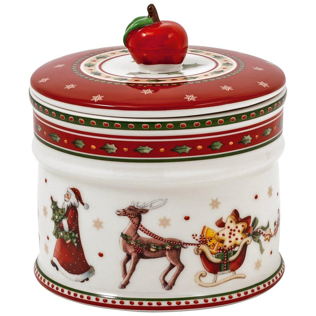 Weihnachtliche Gebäckdose Winter Bakery von Villeroy & Boch mit weihnachtlichen Motiven, einem roten Deckel und einer darauf liegenden Apfelsorte.