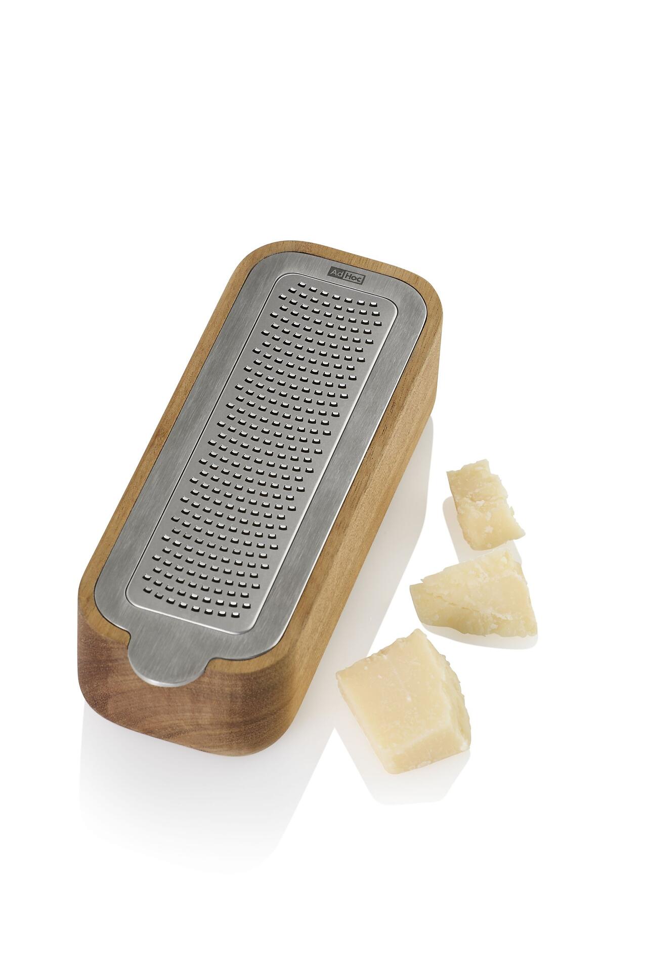 Käsehobel CutnServe mit original AdHoc PreciseGrate-Klinge und Auffangbehälter, dargestellt in Seitenansicht mit dem Fokus auf die feinen Rillen der Klinge und das Hartkäse-Demo.