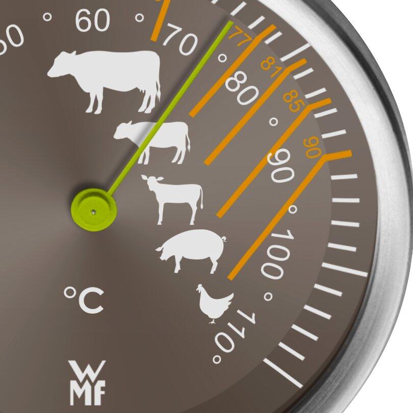 Nahaufnahme eines WMF Fleischthermometers mit silbergrauem Gehäuse und Zifferblatt, das Temperaturen von 60 bis 110 Grad Celsius anzeigt und stilisierte Tierdarstellungen zur Orientierung bei der Garstufe enthält.
