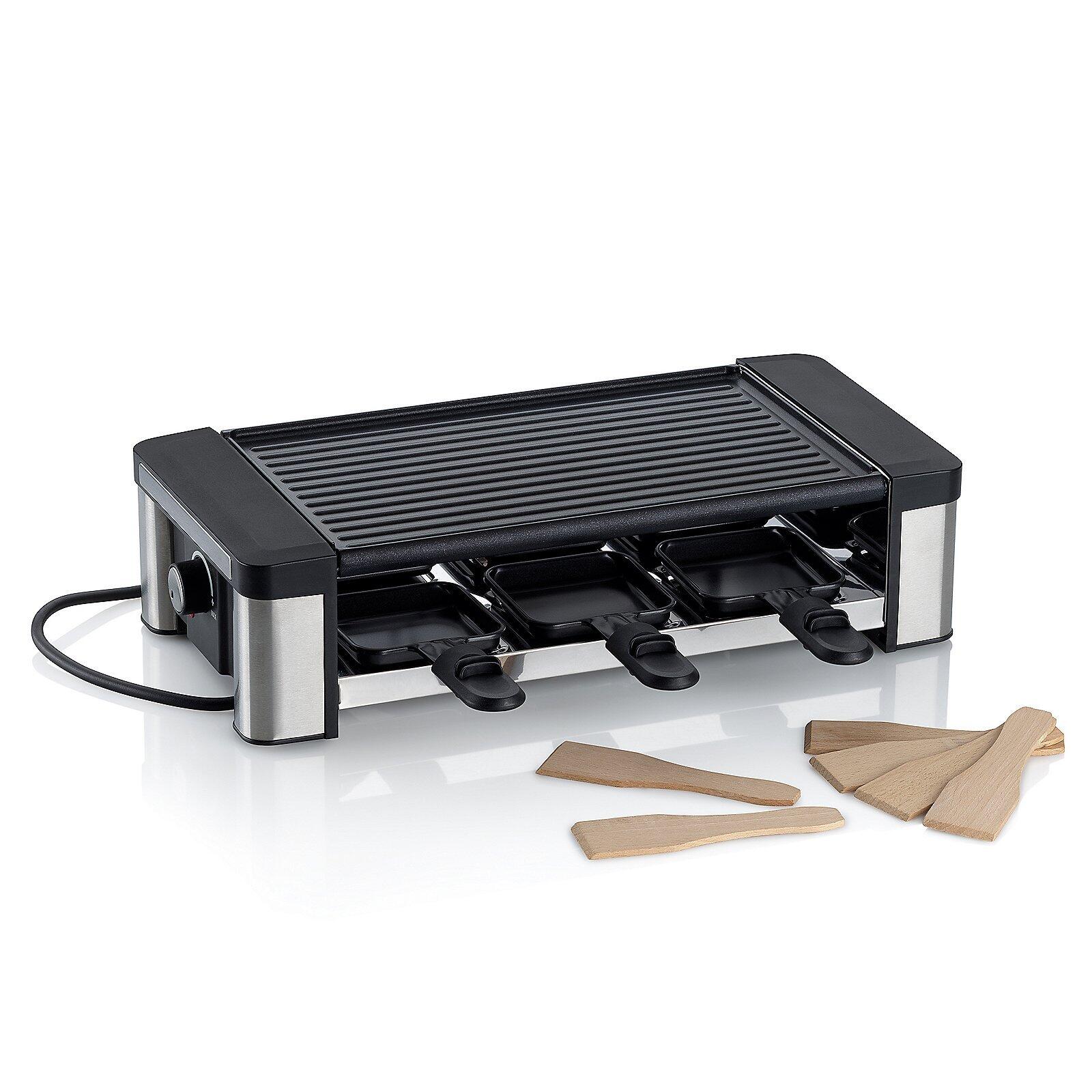 Raclette/Grillplatte Timur: Elektrischer Käsefondue-Satz mit silbernem Metallrahmen, schwarzer Antihaftbeschichtung und vier integrierten Gabeln, aus Vogelperspektive.
