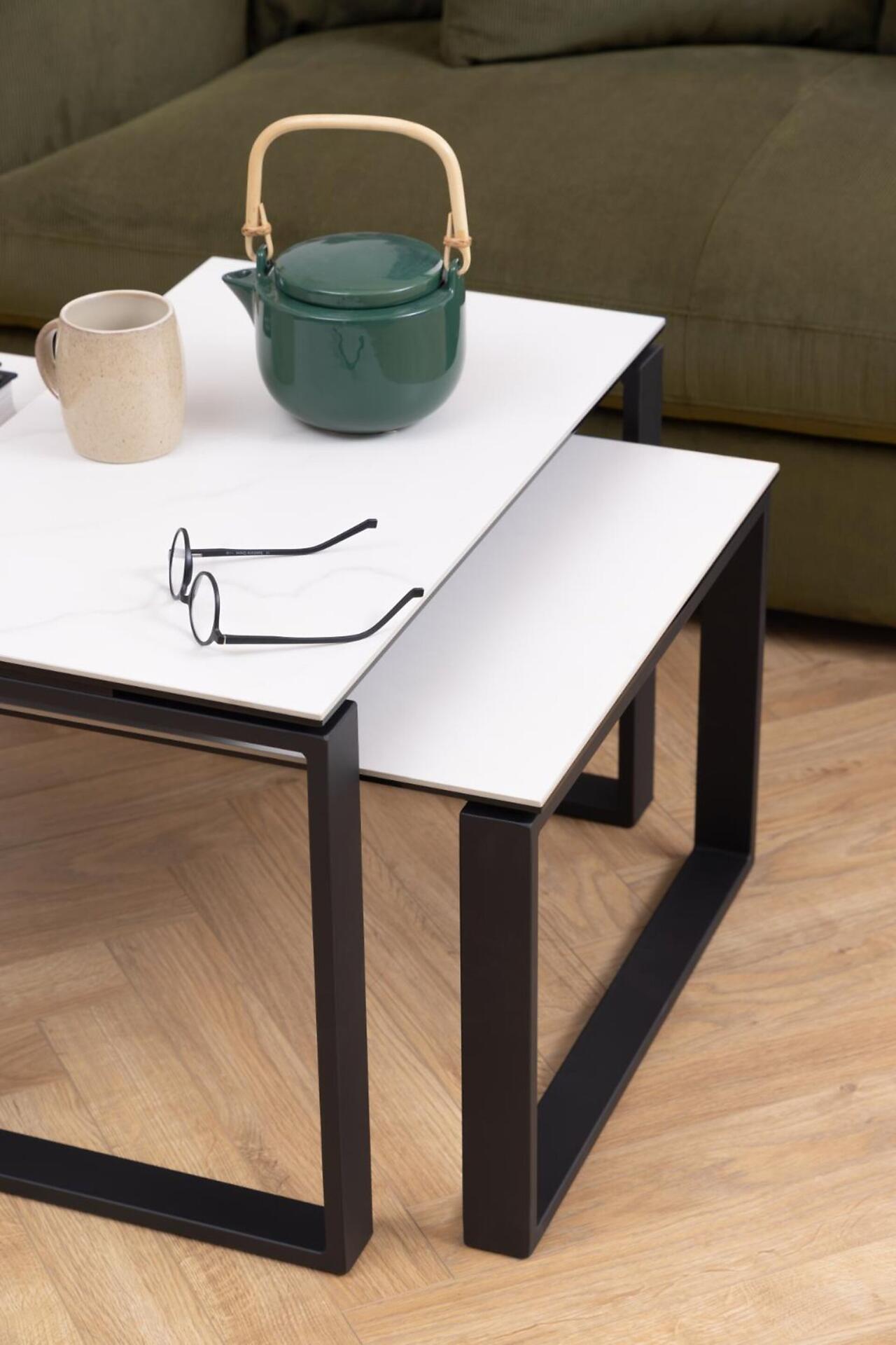 Couchtisch Katrine aus hellem Holz mit weißer Tischplatte und schwarzem Metallgestell, aus Perspektive leicht von unten mit Teekanne und Tasse.