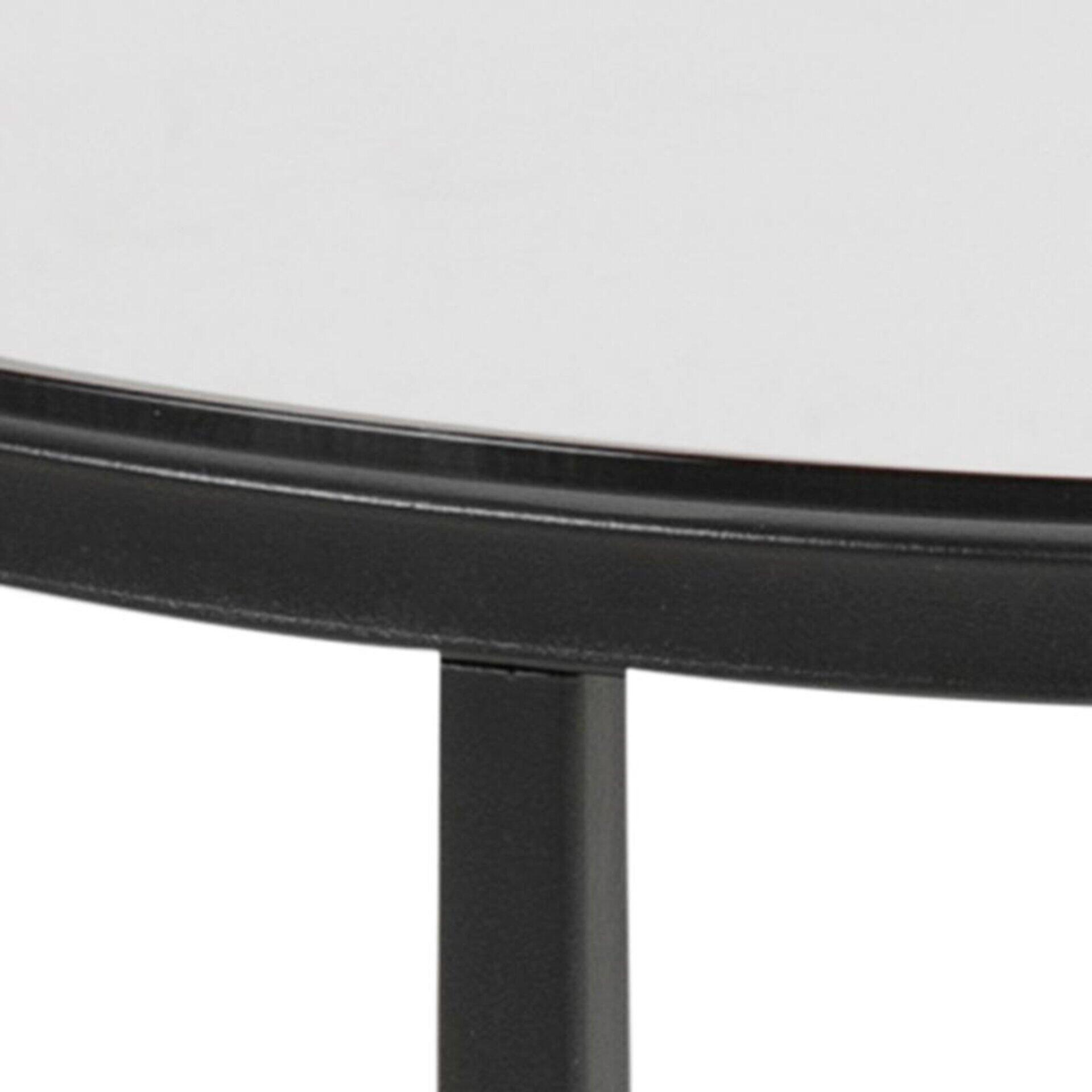 Nahaufnahme des Ecktischs Cross mit weißer, glänzender Tischplatte in rundem Design, umgeben von einem schwarzen Rahmen und mit einem schlanken, schwarzen Metallbein.