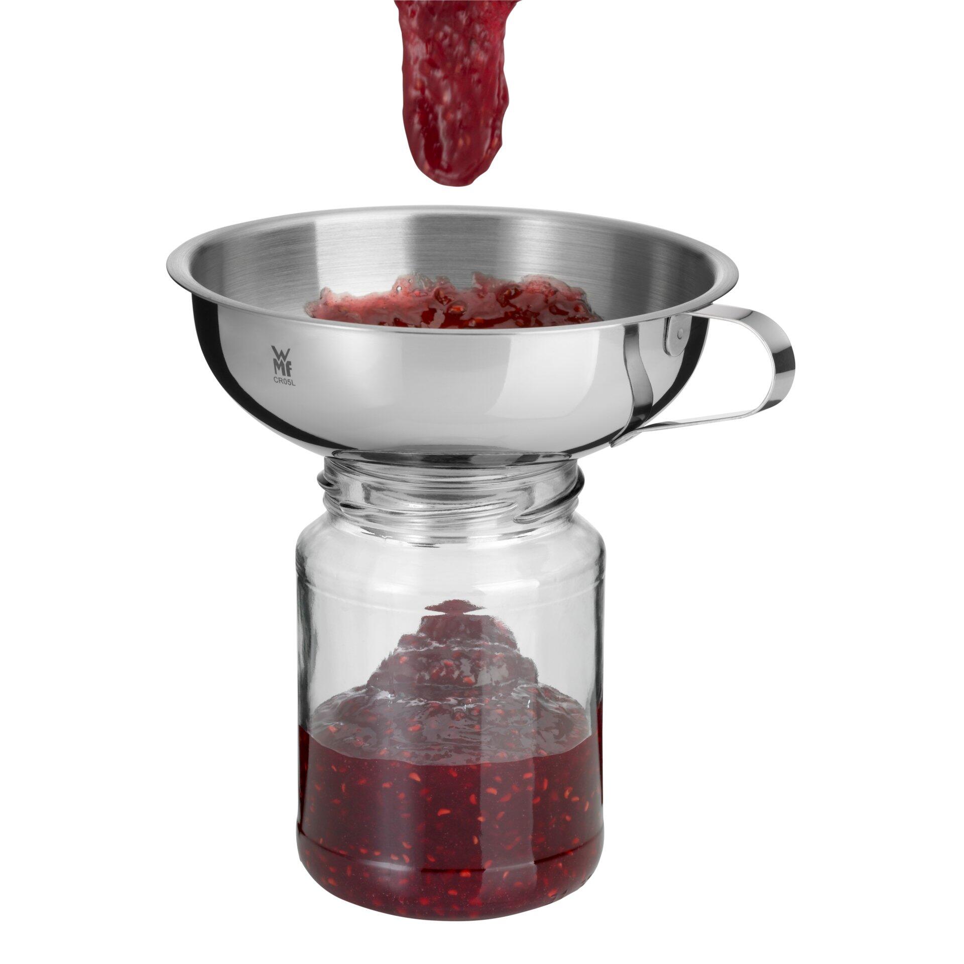 WMF Gourmet Marmeladentrichter aus Edelstahl in Vogelperspektive, der Johannisbeerpüree in ein Glas füllt.