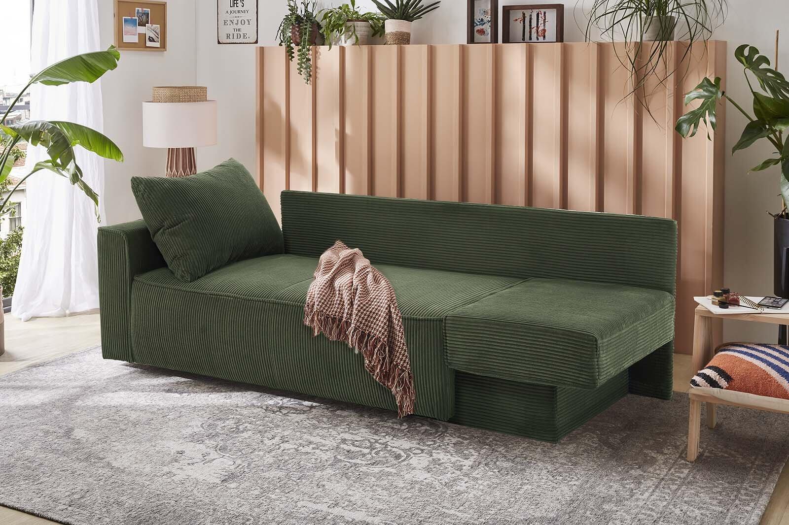 Grünes Schlafsofa Modell Ron mit flexiblen Elementen und ausziehbarer Liegefläche, leicht seitlich betrachtet in einem stilvollen Wohnzimmer.