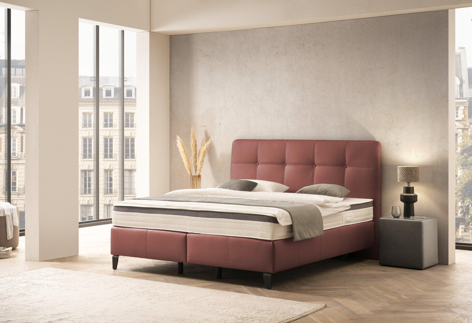 Boxspringbett "Wien" mit grauem Kunstlederbezug und gesteiftem Kopfteil, Blickwinkel schräg zur Darstellung des Gesamtbildes.