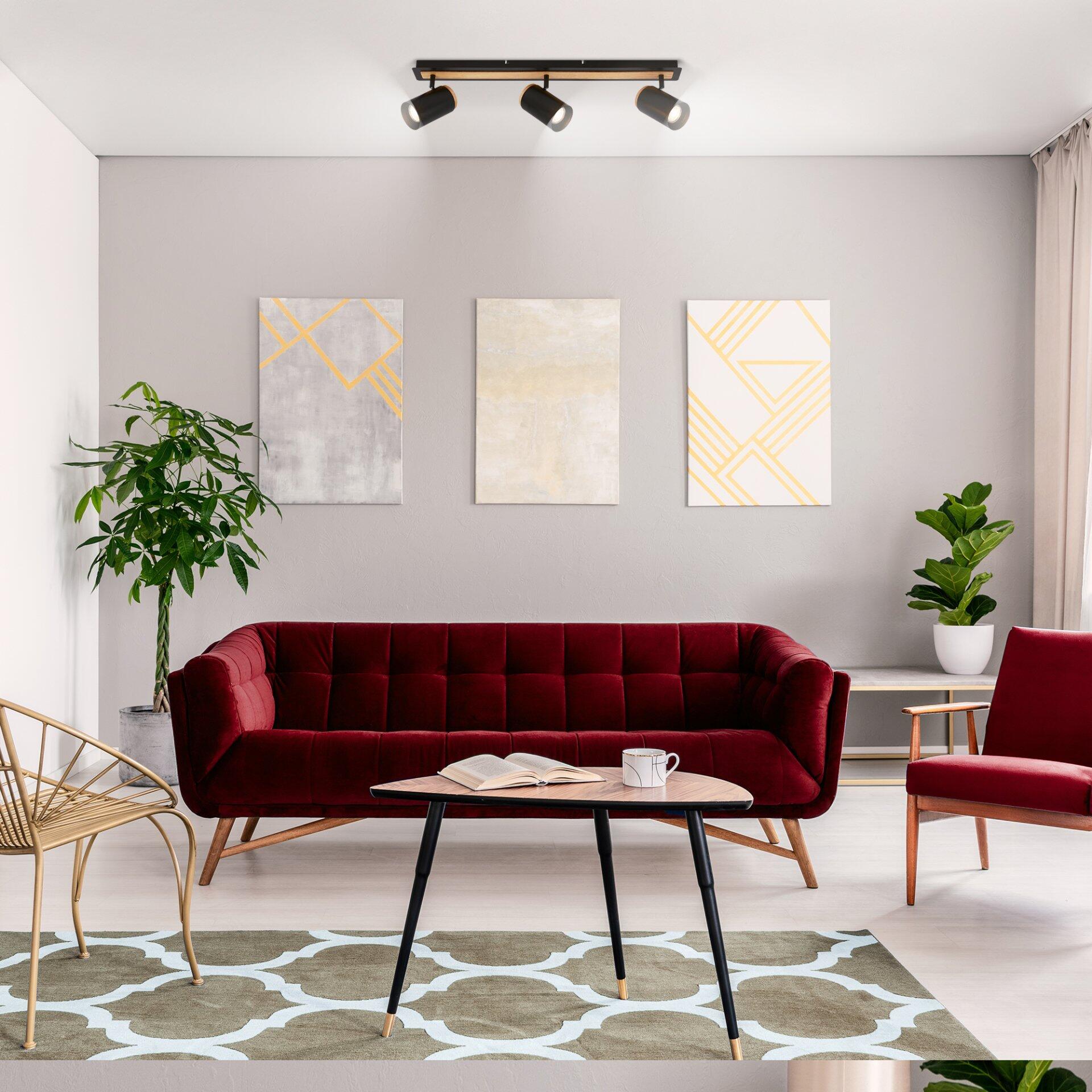 Spot, Duta: Spotlight-Leuchte an der Wand in einem stilvollen Wohnzimmer mit rotem Samtsessel und Couchtisch.