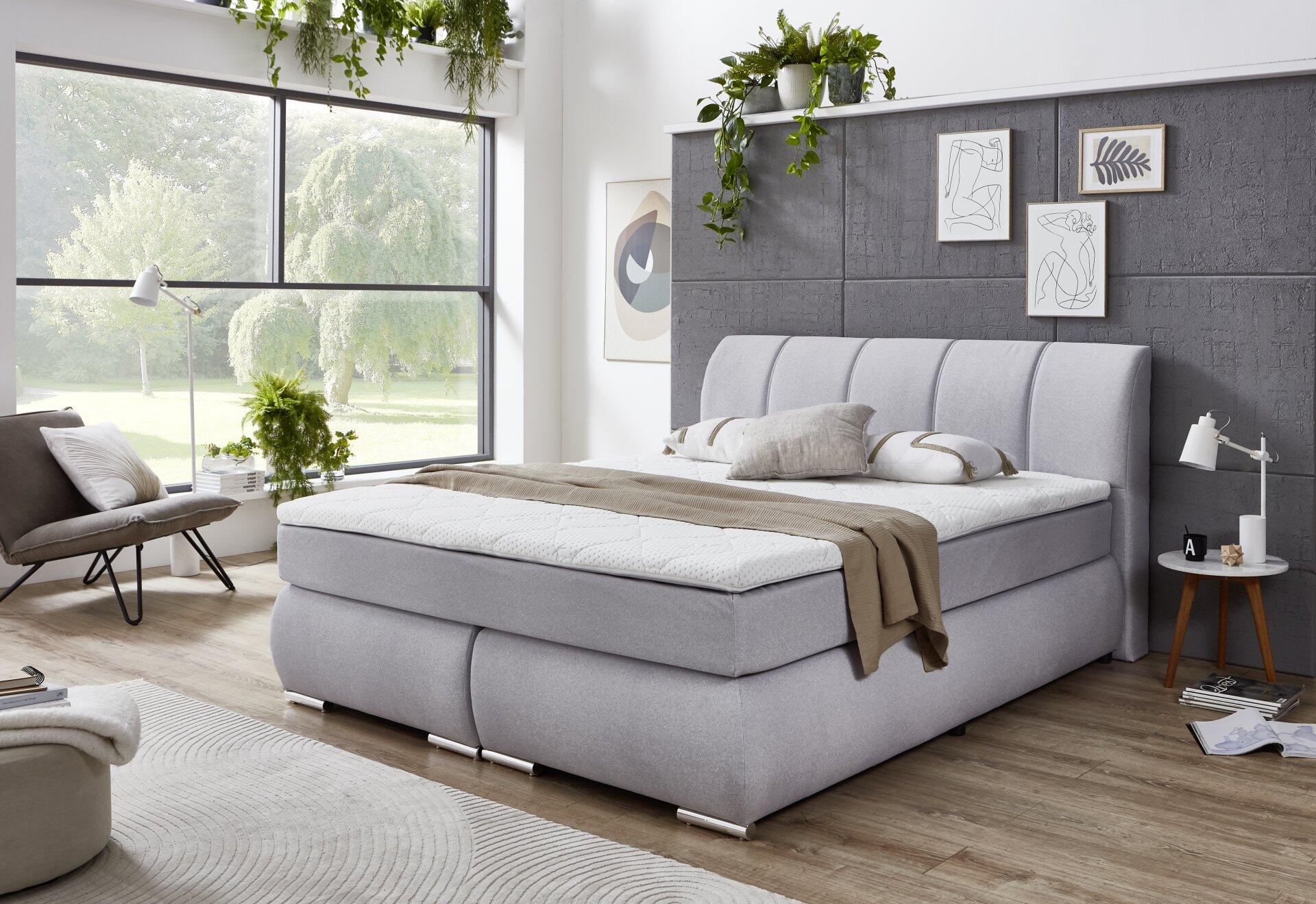 Helles Boxspringbett Graz BX2630 mit hoher, gesteppter Kopfteil und integrierter Unterbox, präsentiert in einem stilvollen Schlafzimmer.