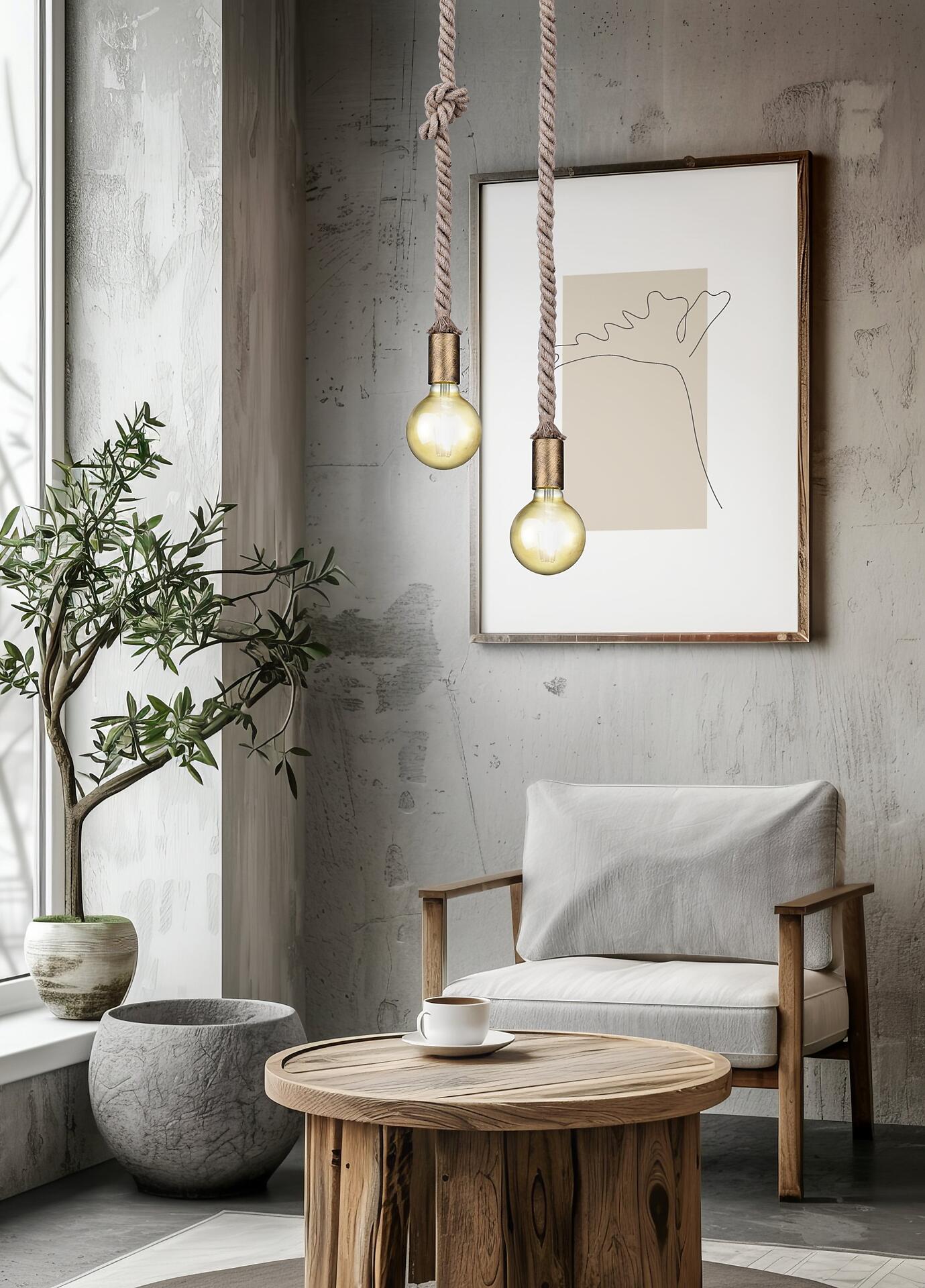 Pendelleuchte Rope mit Seilaufhängung und Messing-Elementen, die über einem Couchtisch im Raum hängt und eine warme Atmosphäre schafft.