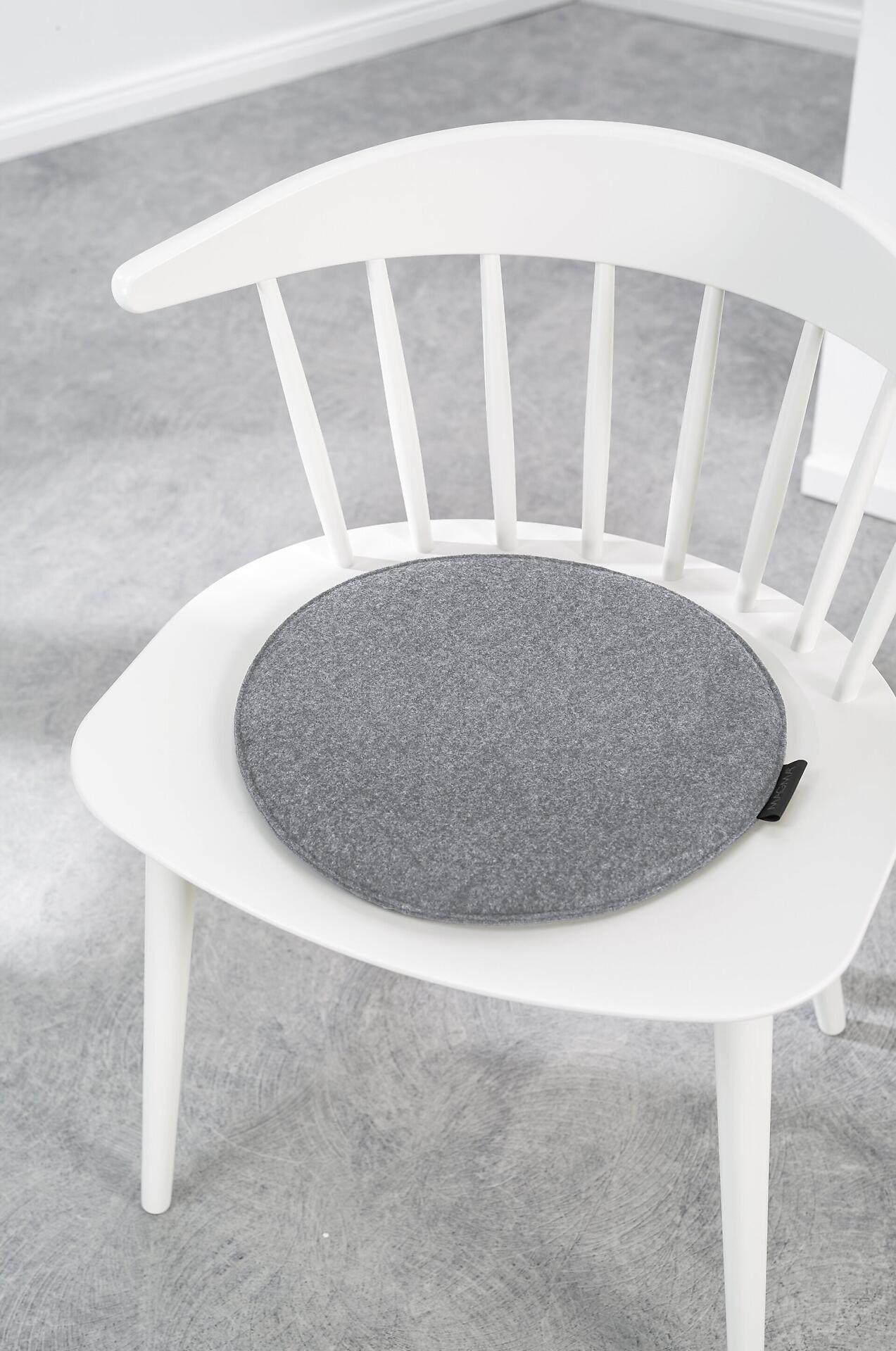 Sitzkissen Form 45 Avaro in Grau auf einem Stuhl, Detailaufnahme von hinten mit Fokus auf die Schaumstoff-Füllung und die Naht.