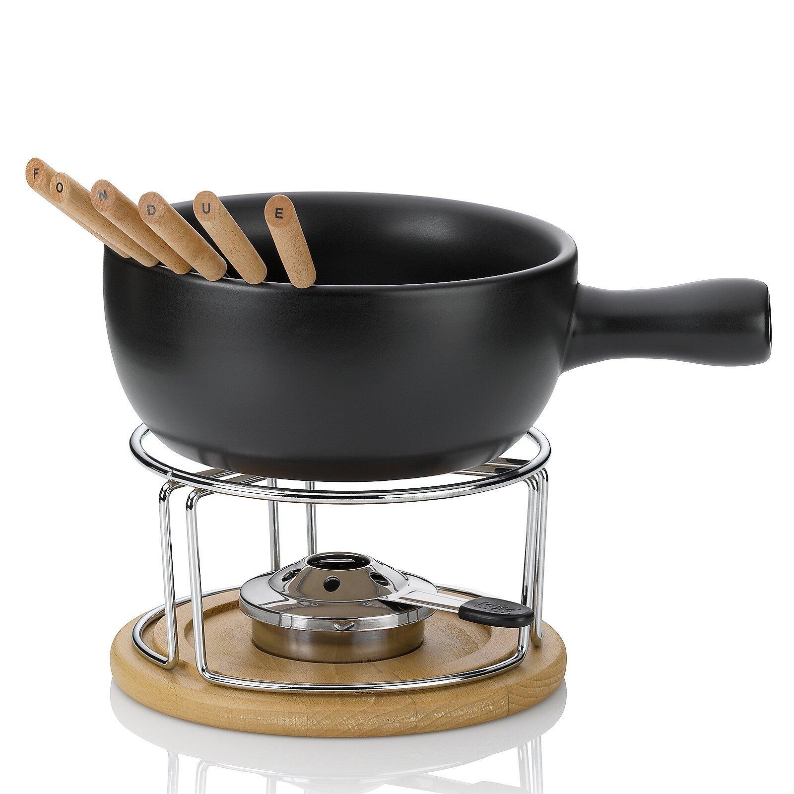 Käsefondue-Set Natura mit schwarzem Keramik-Fondue-Topf, Kochbrenner mit einstellbarer Flamme und Bambus-Ring, aus der Vogelperspektive auf Holzunterlage.